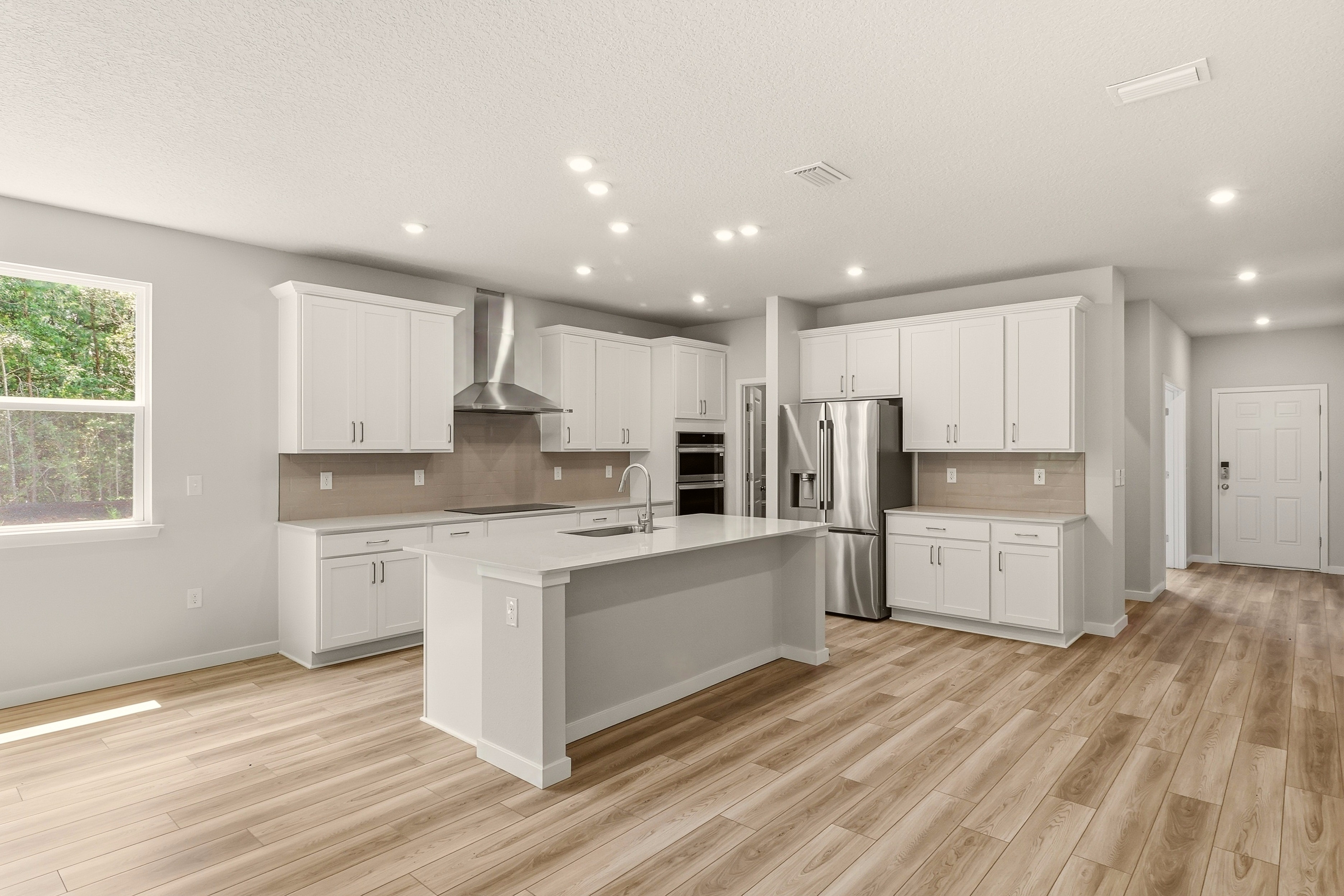 A kitchen with white cabinets.