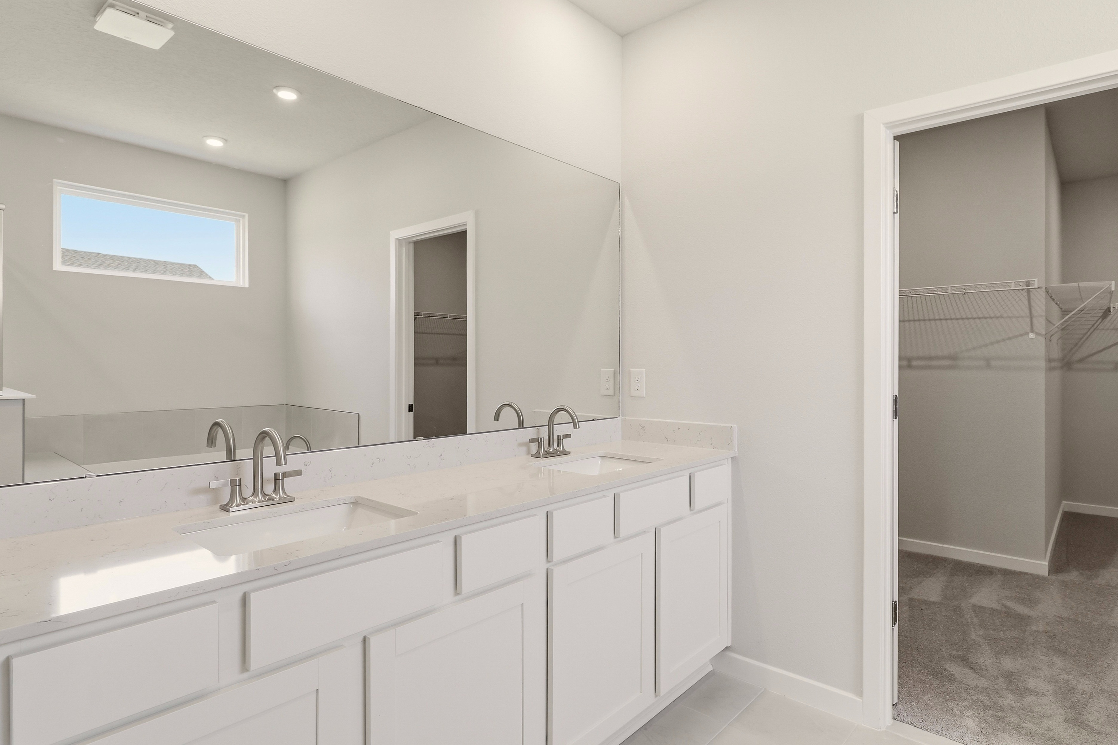 A bathroom with white cabinets.