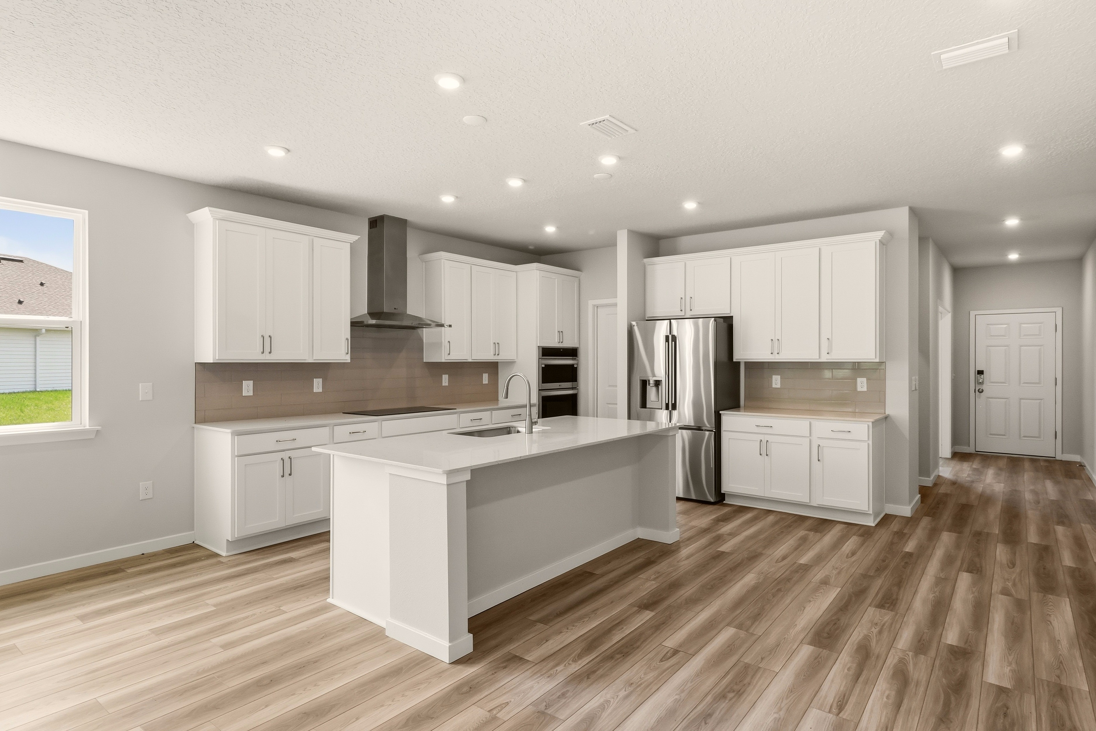 A kitchen with white cabinets.