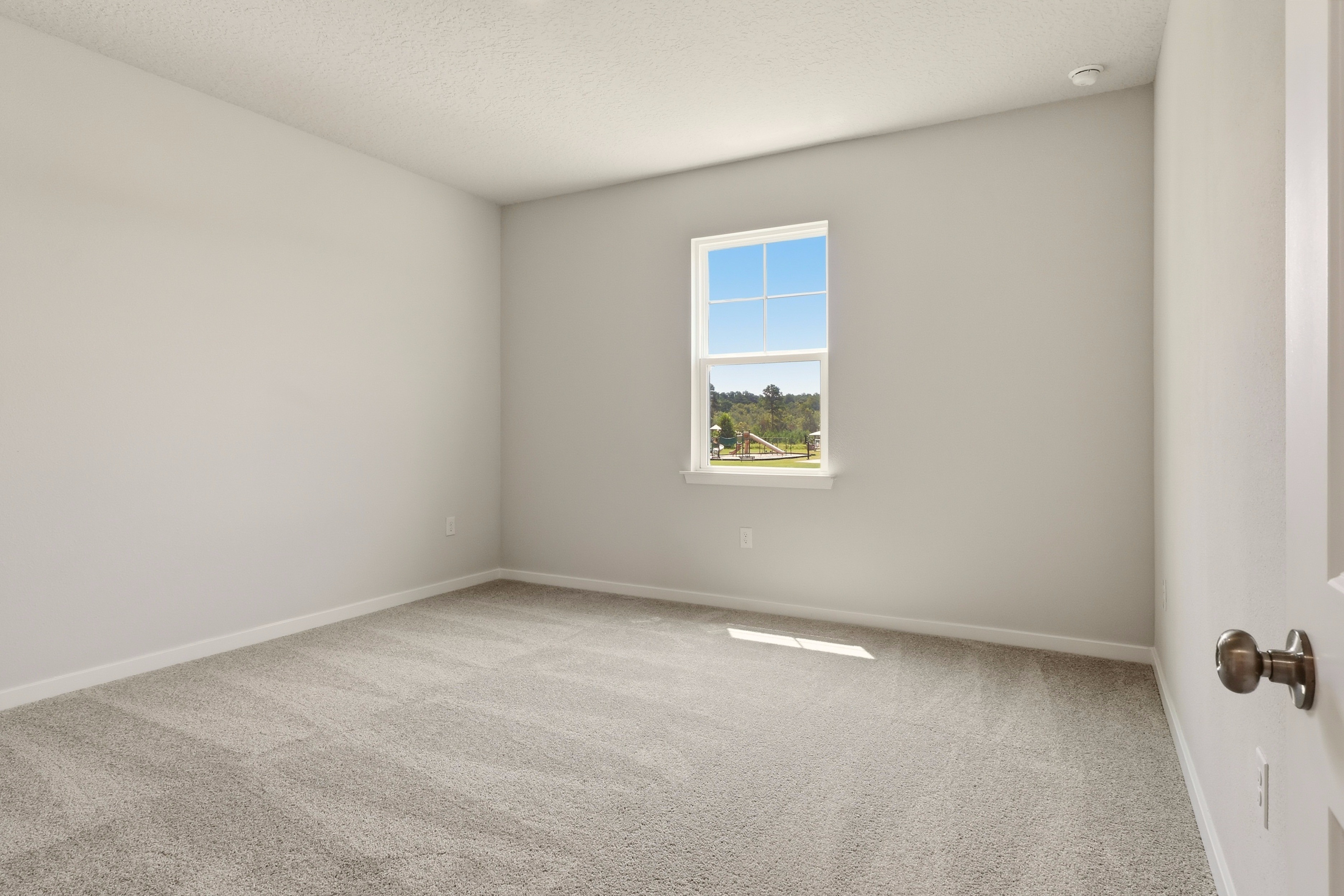 A room with a window and carpet.