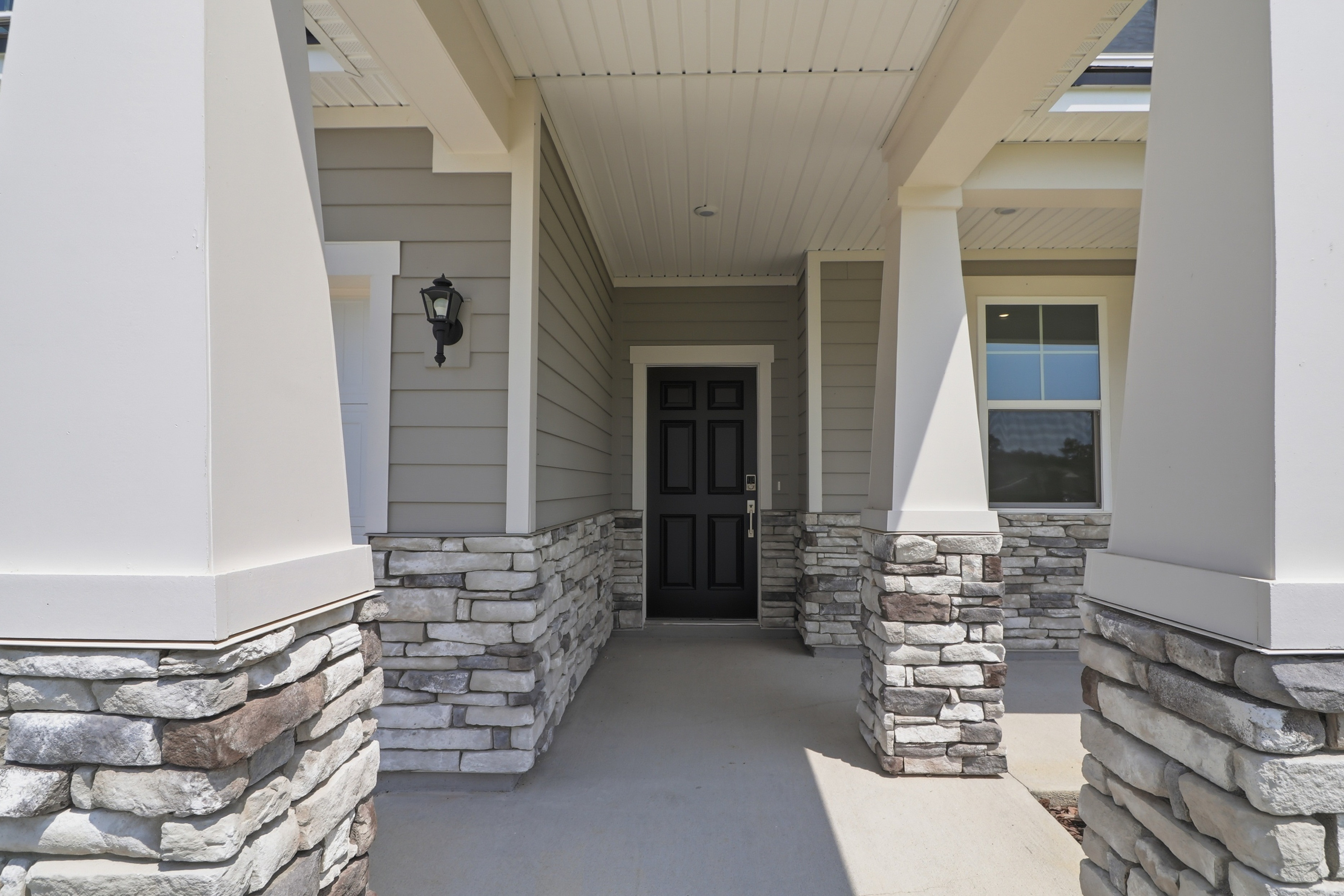 A stone walkway with a door and windows.