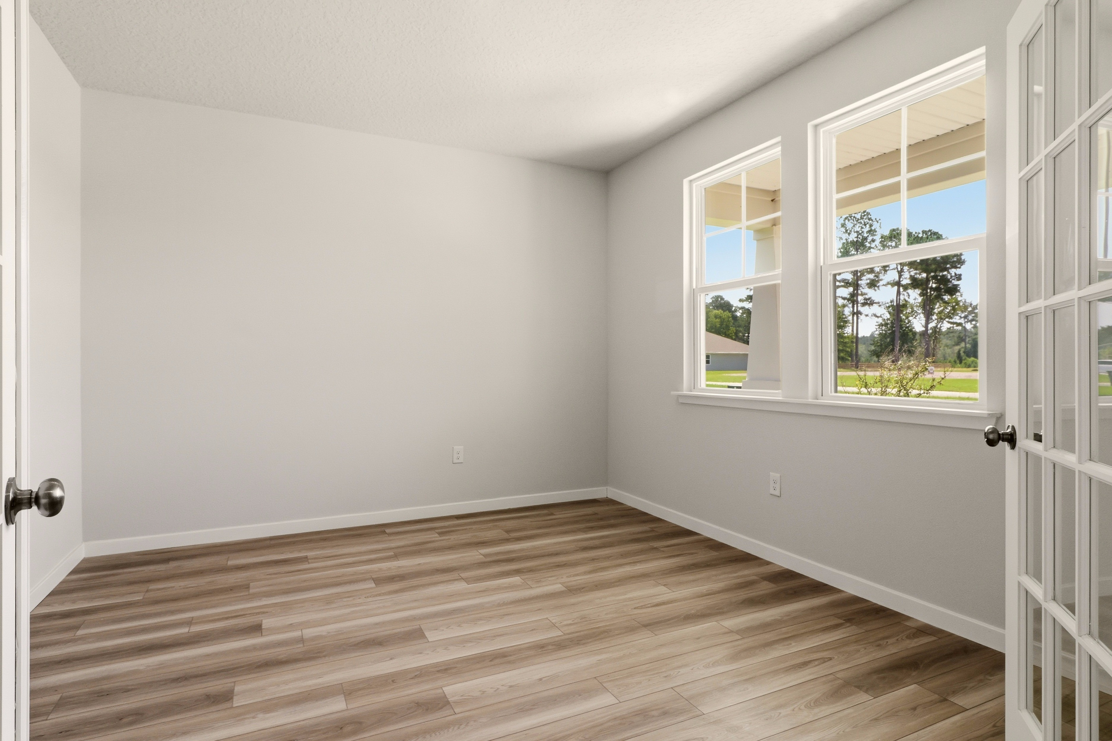 A room with windows and wood floor.
