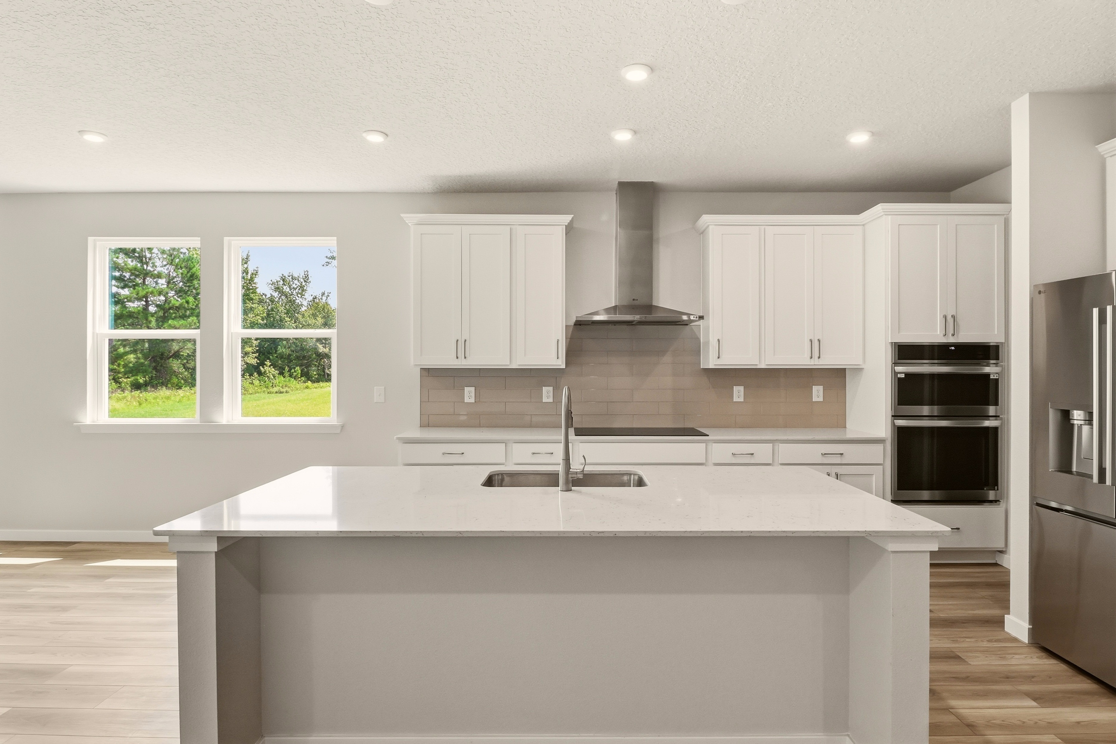 A kitchen with white cabinets.