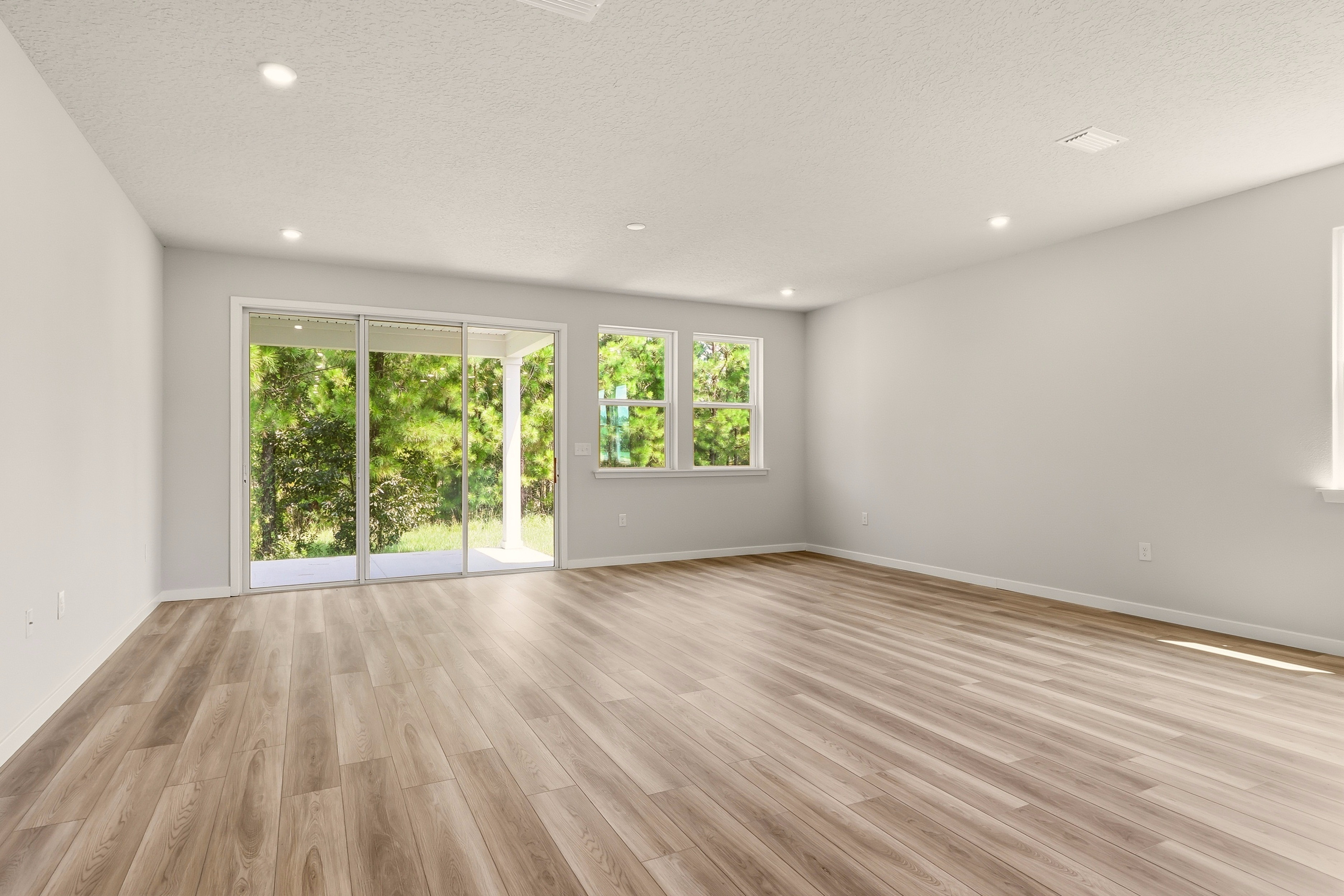 A room with a wood floor and a window with a wood floor.