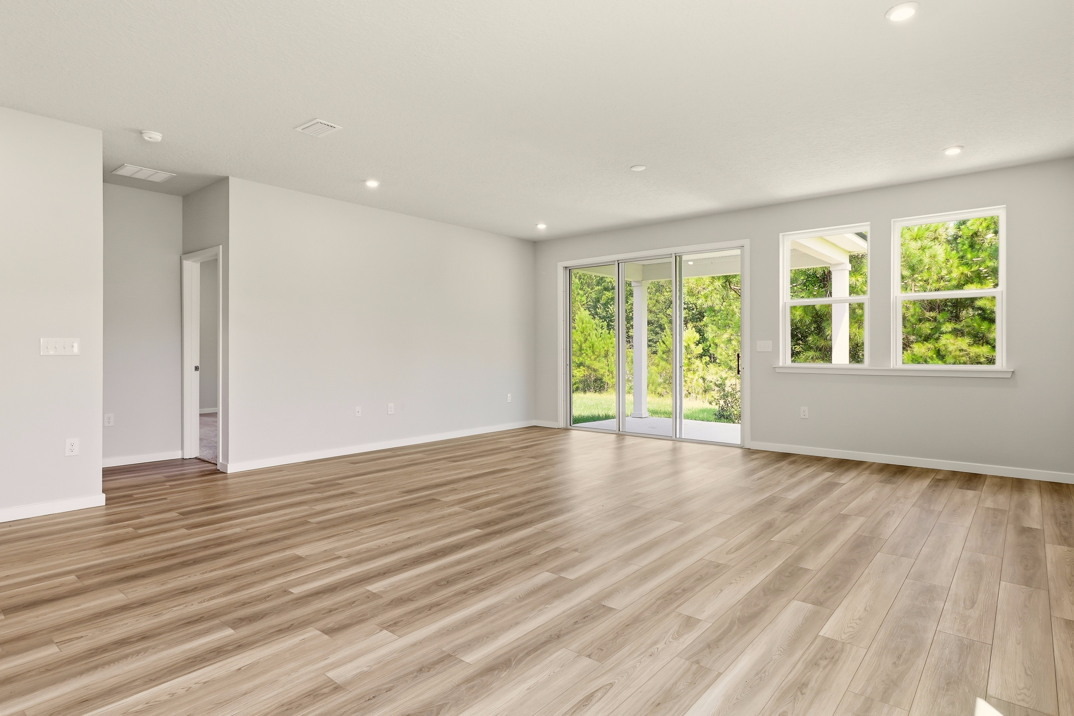 A room with a wood floor and windows.