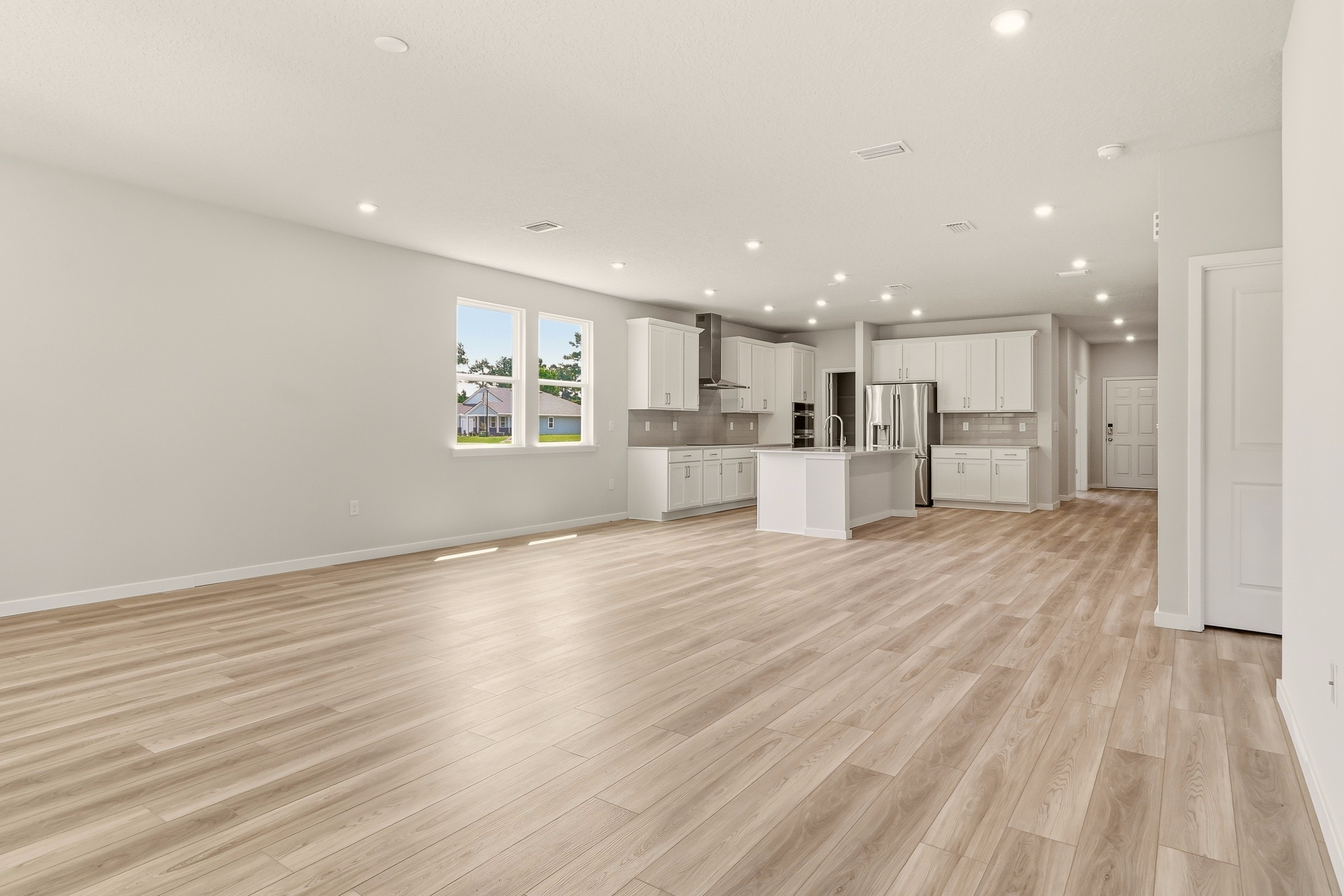 A large empty room with white cabinets.