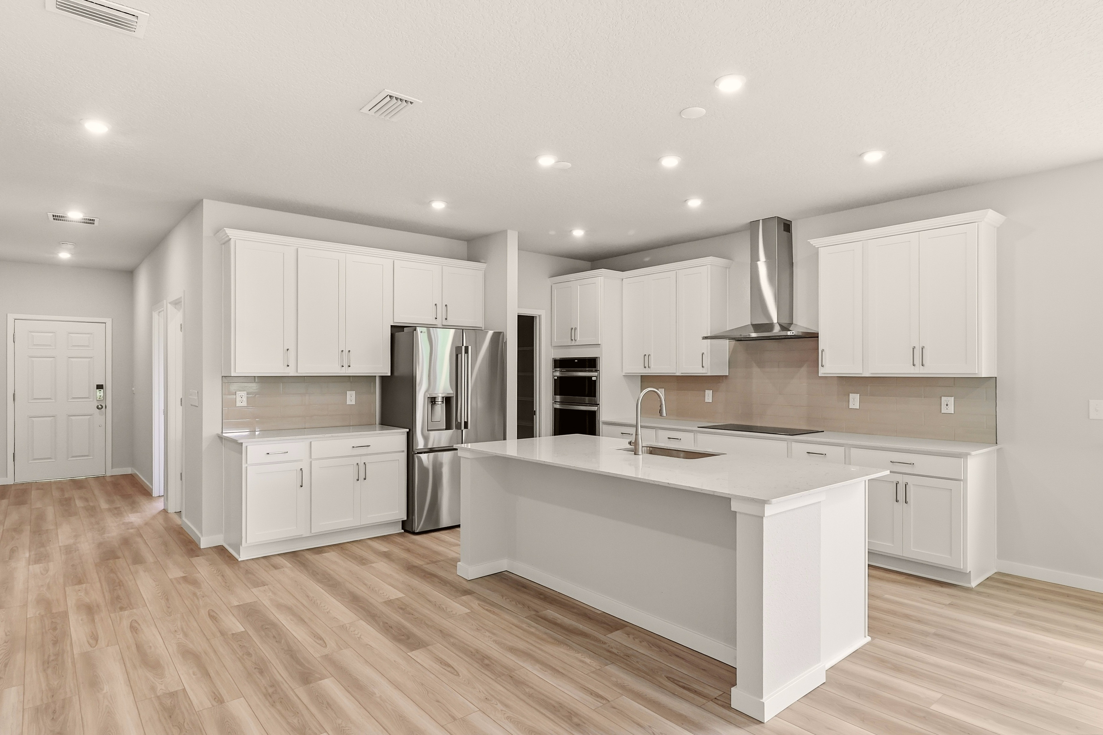 A kitchen with white cabinets.