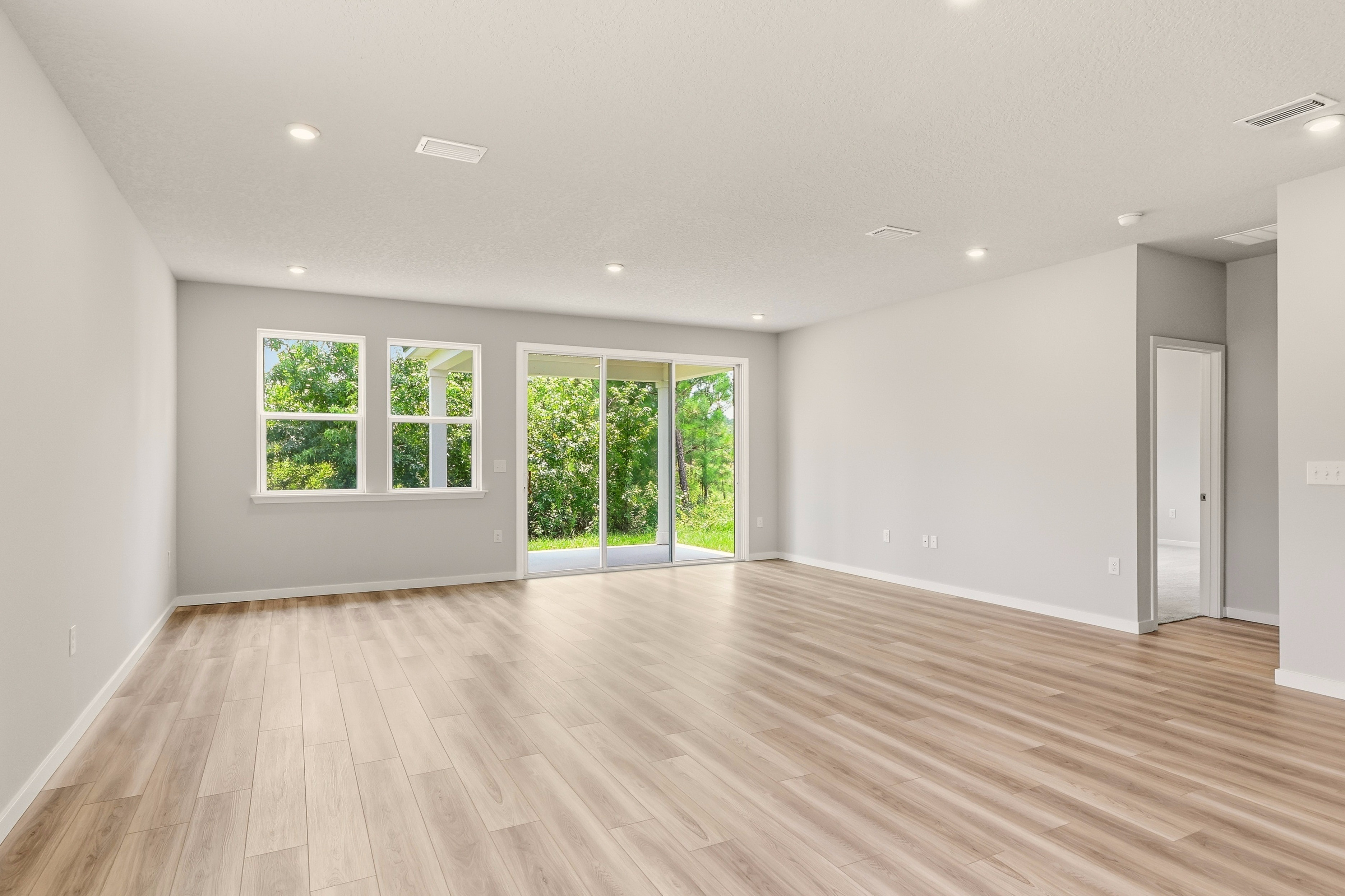 A room with a wood floor and windows.