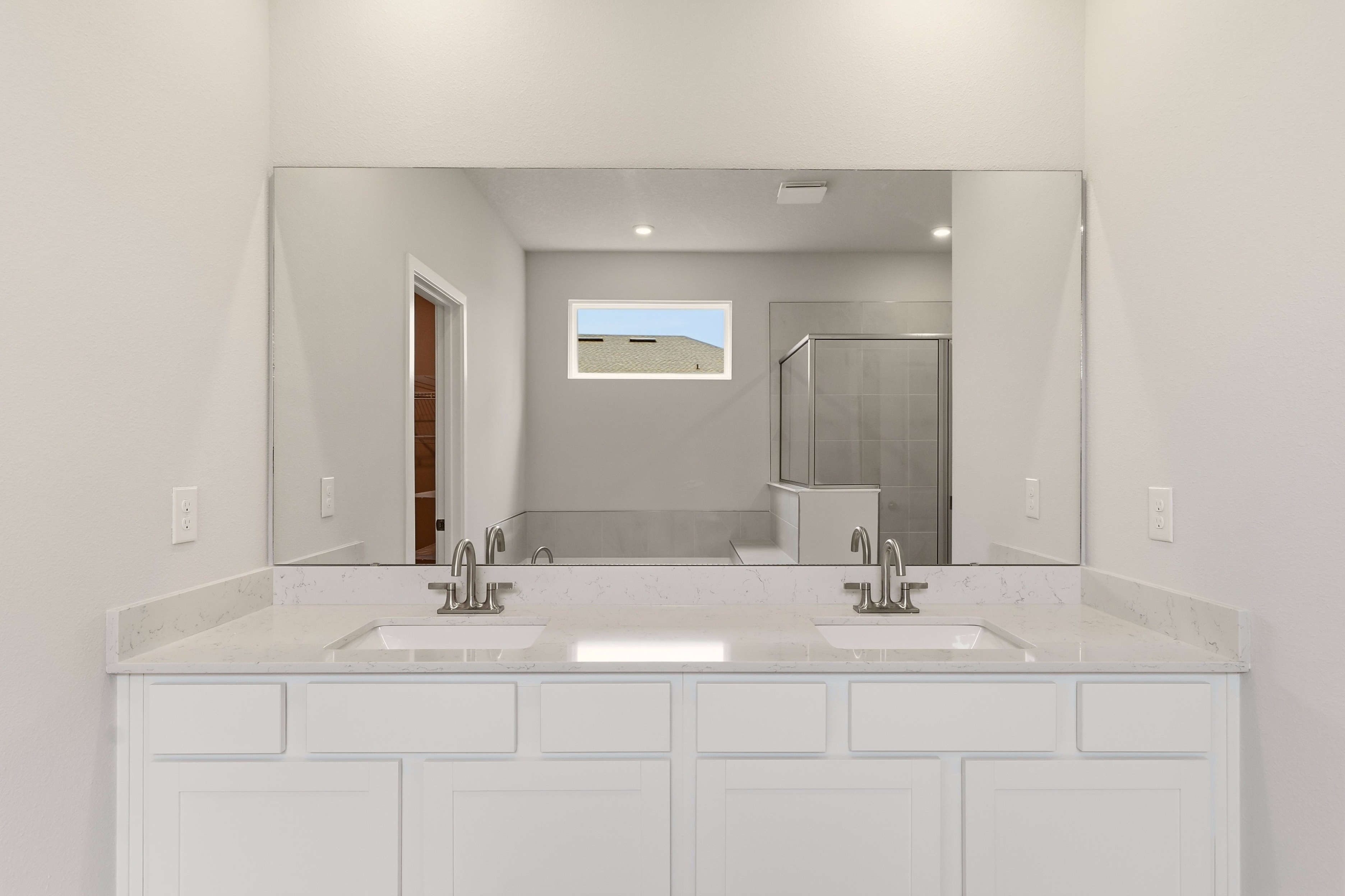A bathroom with white cabinets.
