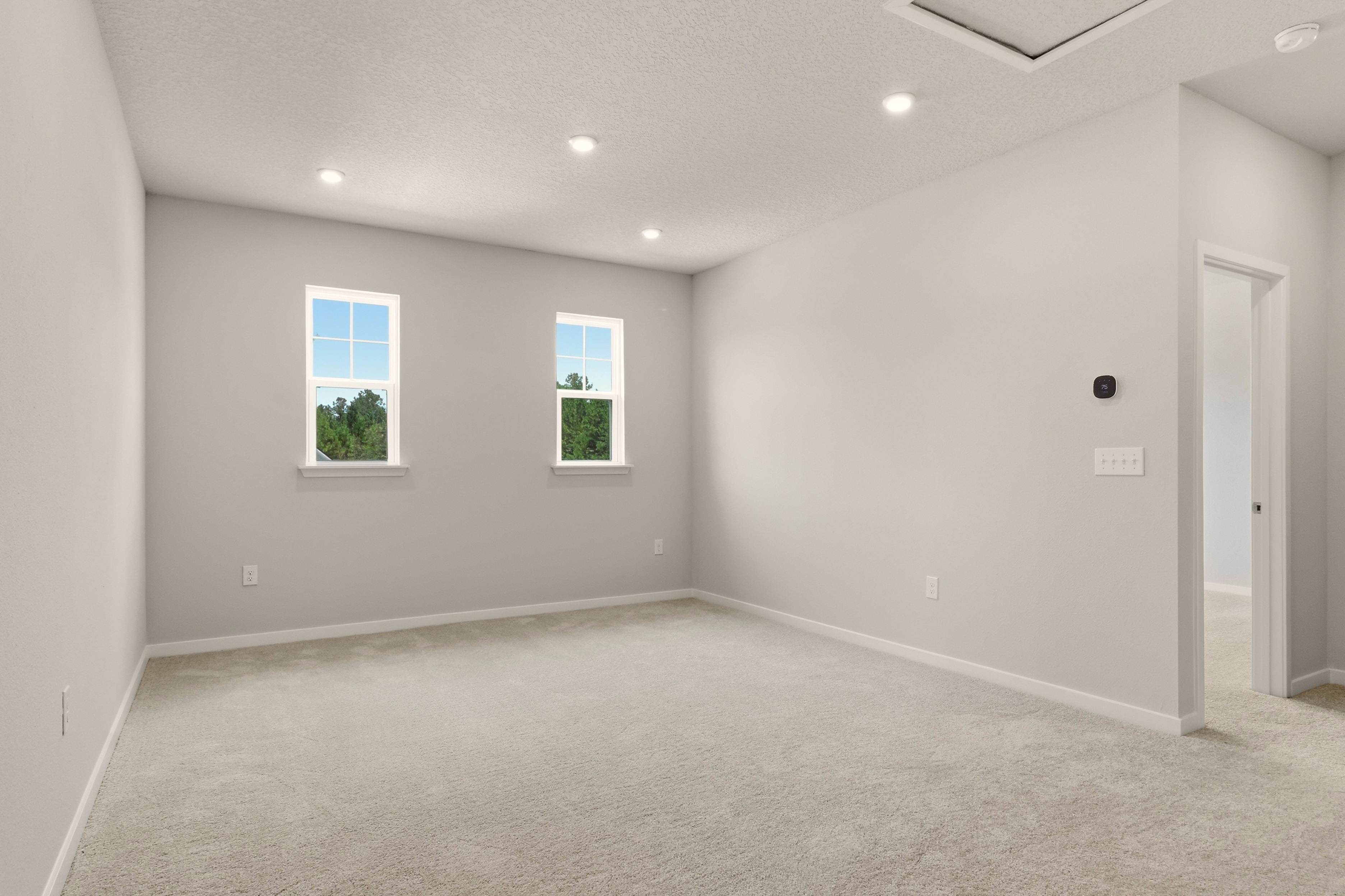 A room with a carpet and windows.