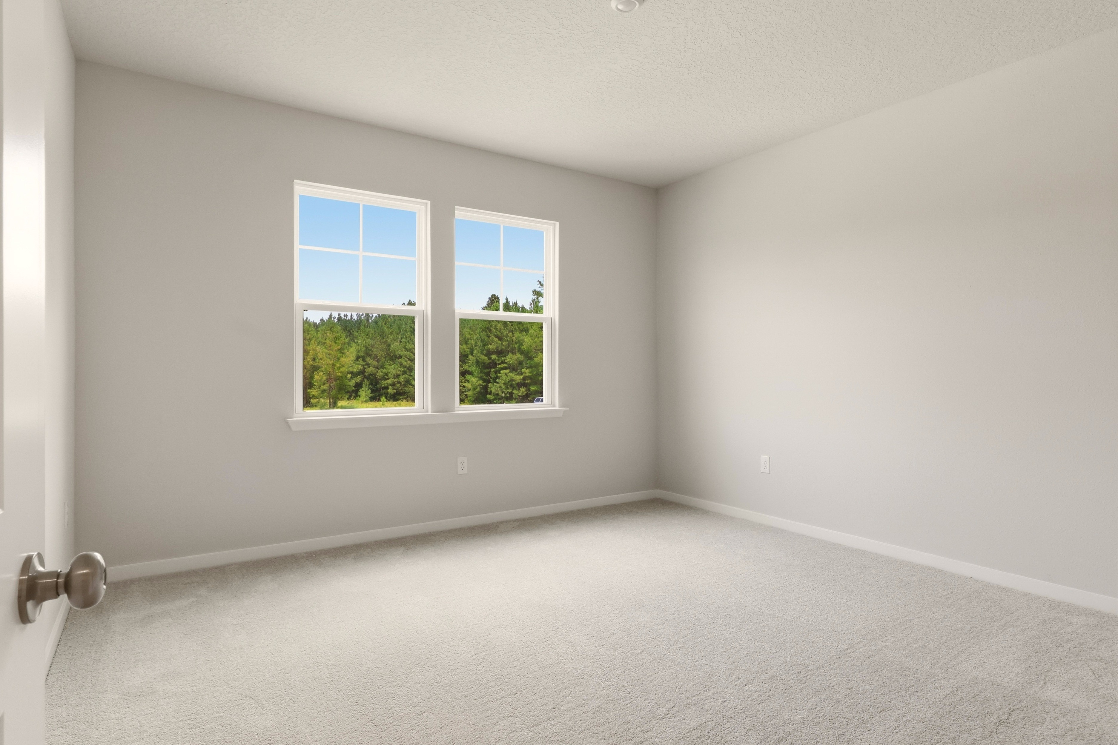 A room with a window and a carpet.