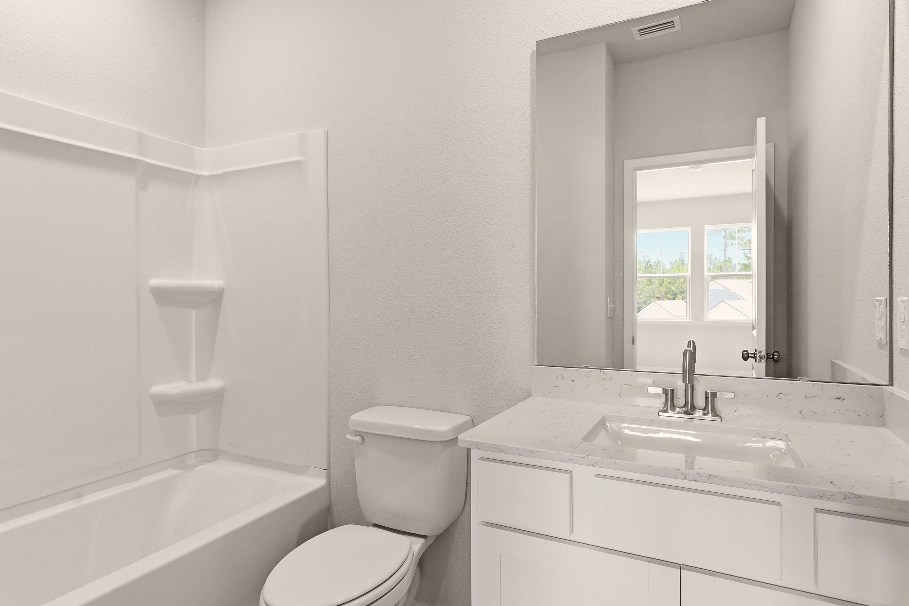 A bathroom with a tub sink and toilet.