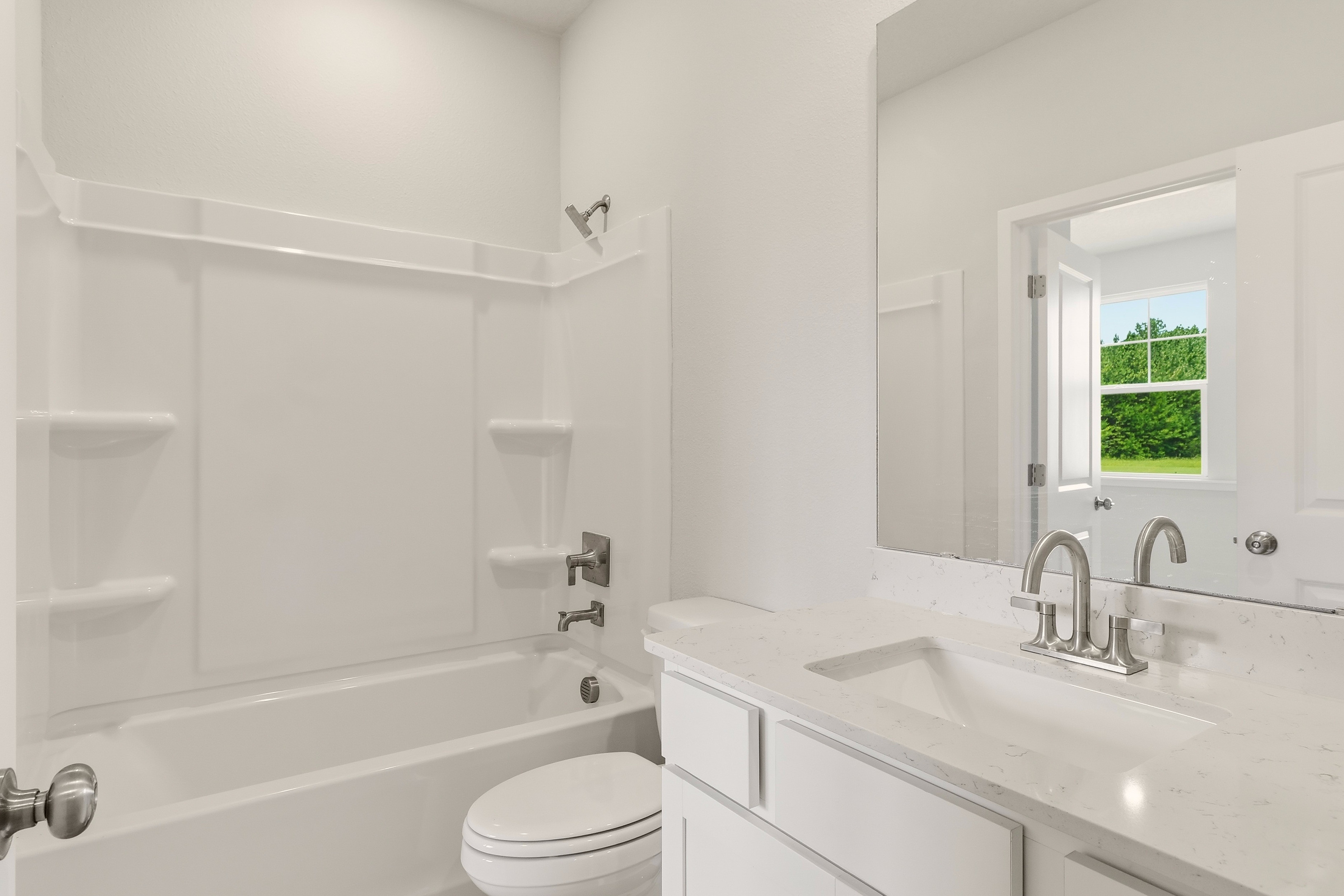 A bathroom with a tub sink and toilet.
