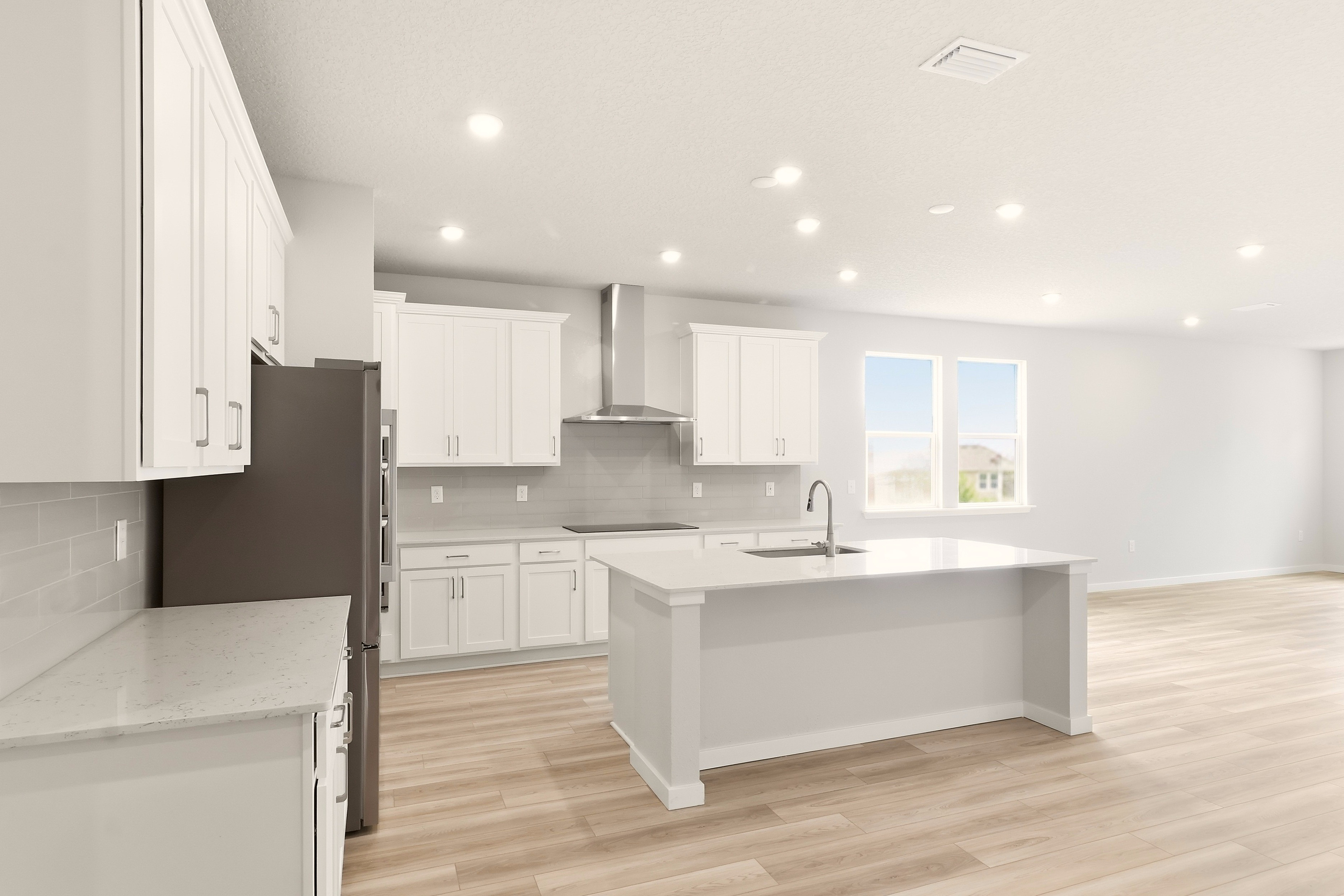 A kitchen with white cabinets.