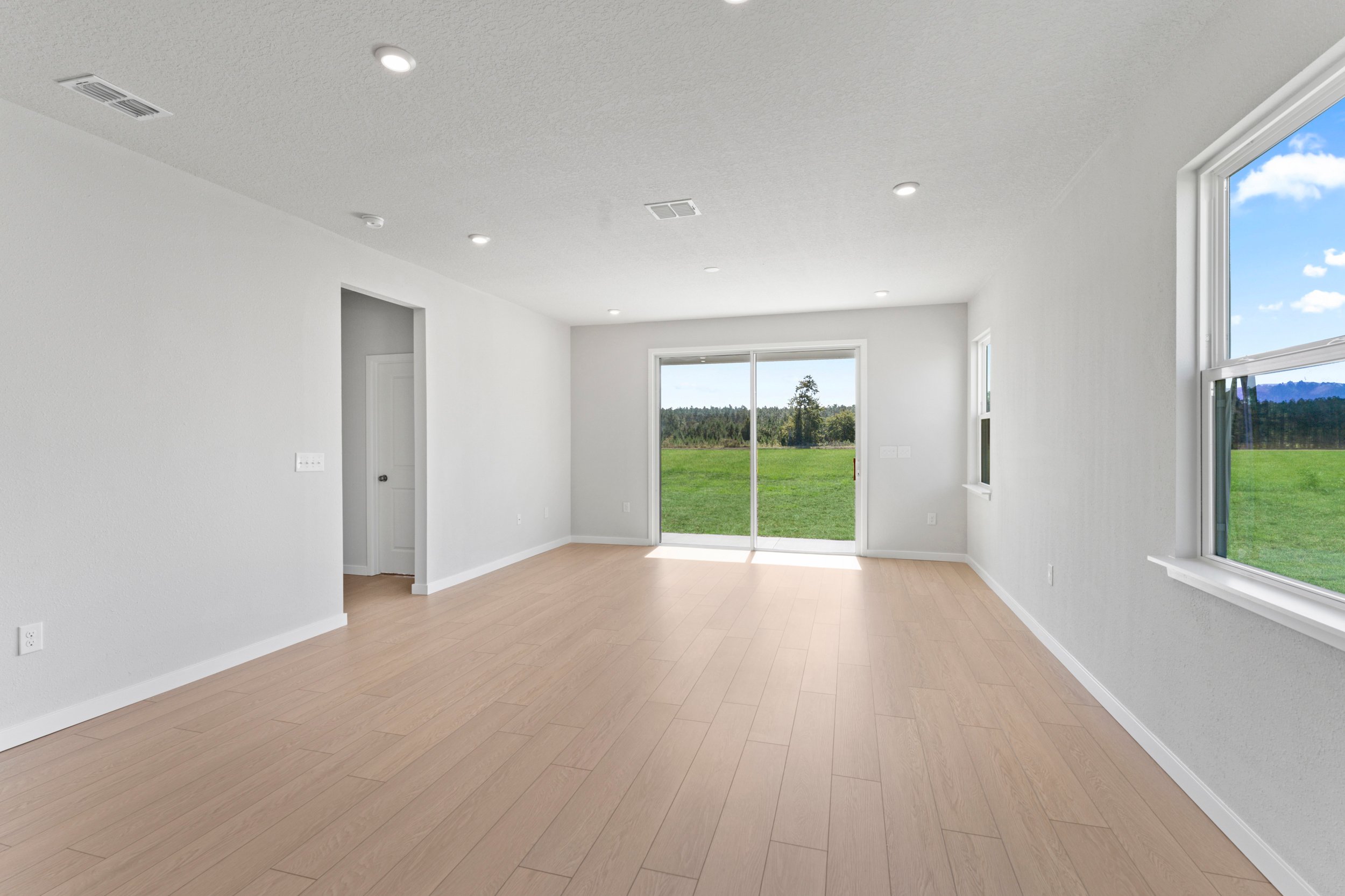 A room with a wood floor and windows.