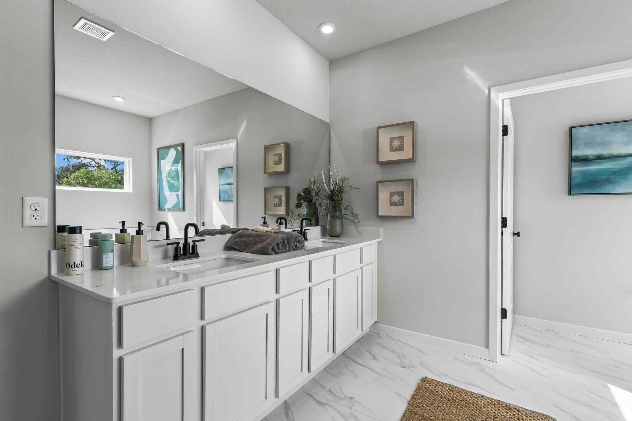 A bathroom with white cabinets.