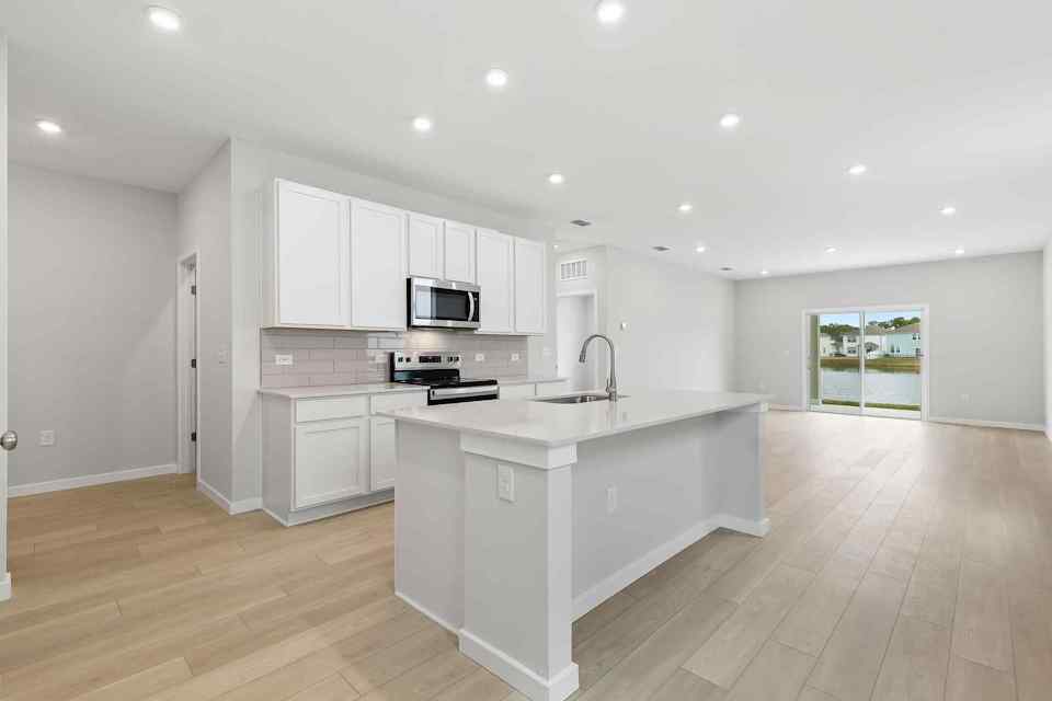 A kitchen with white cabinets.
