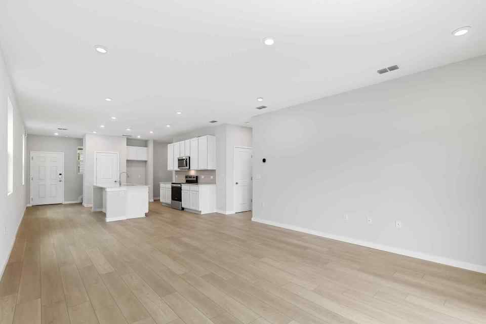 A large empty room with white cabinets.