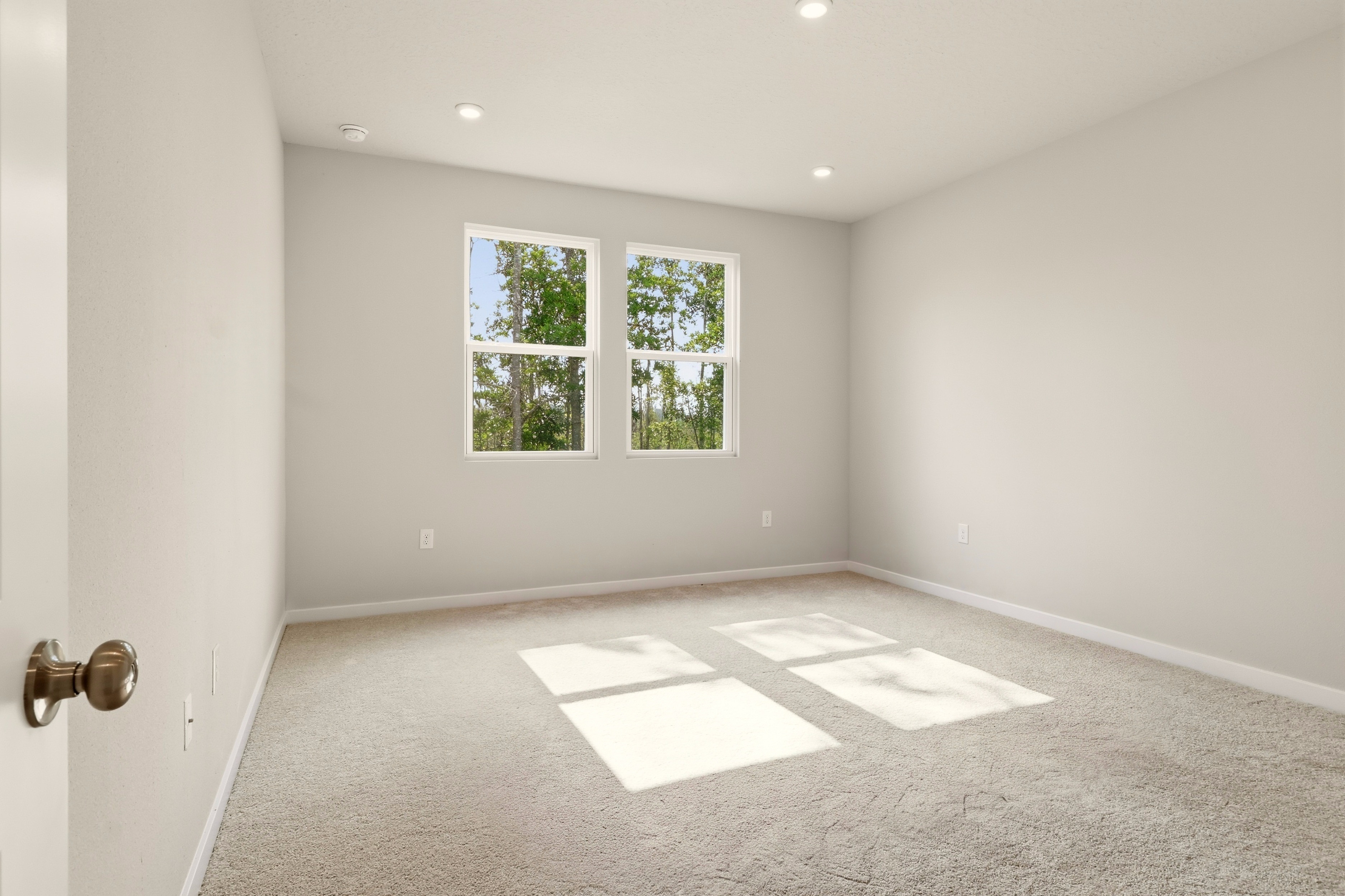 A room with a window and carpet.