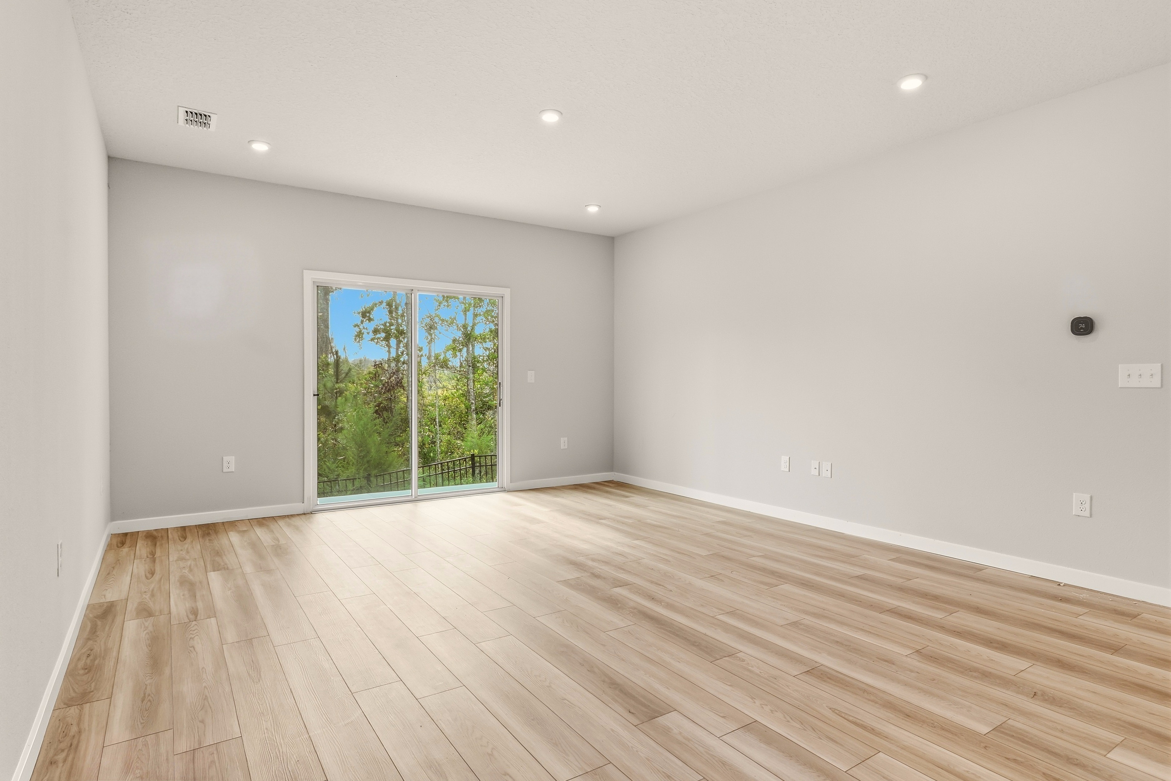 A room with a wood floor and a window.