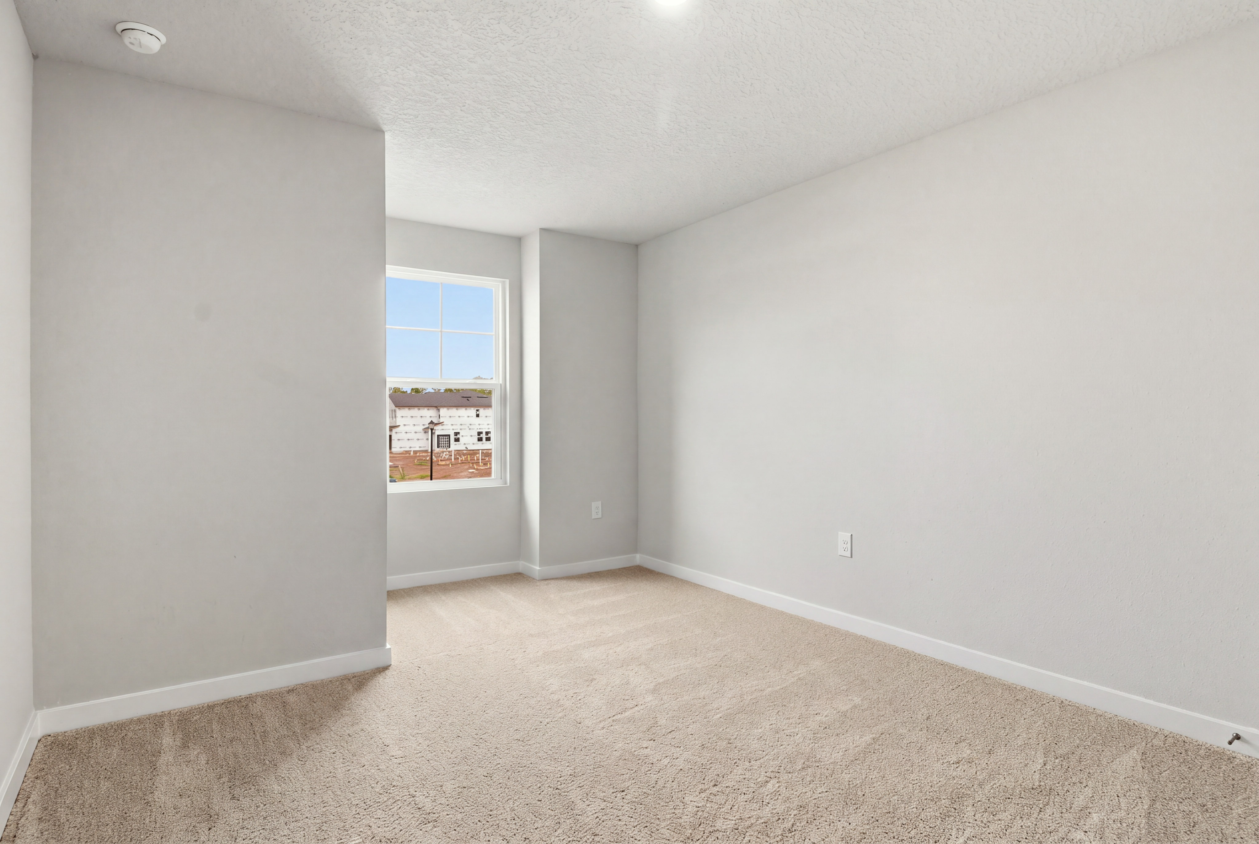A room with a window and a carpet.