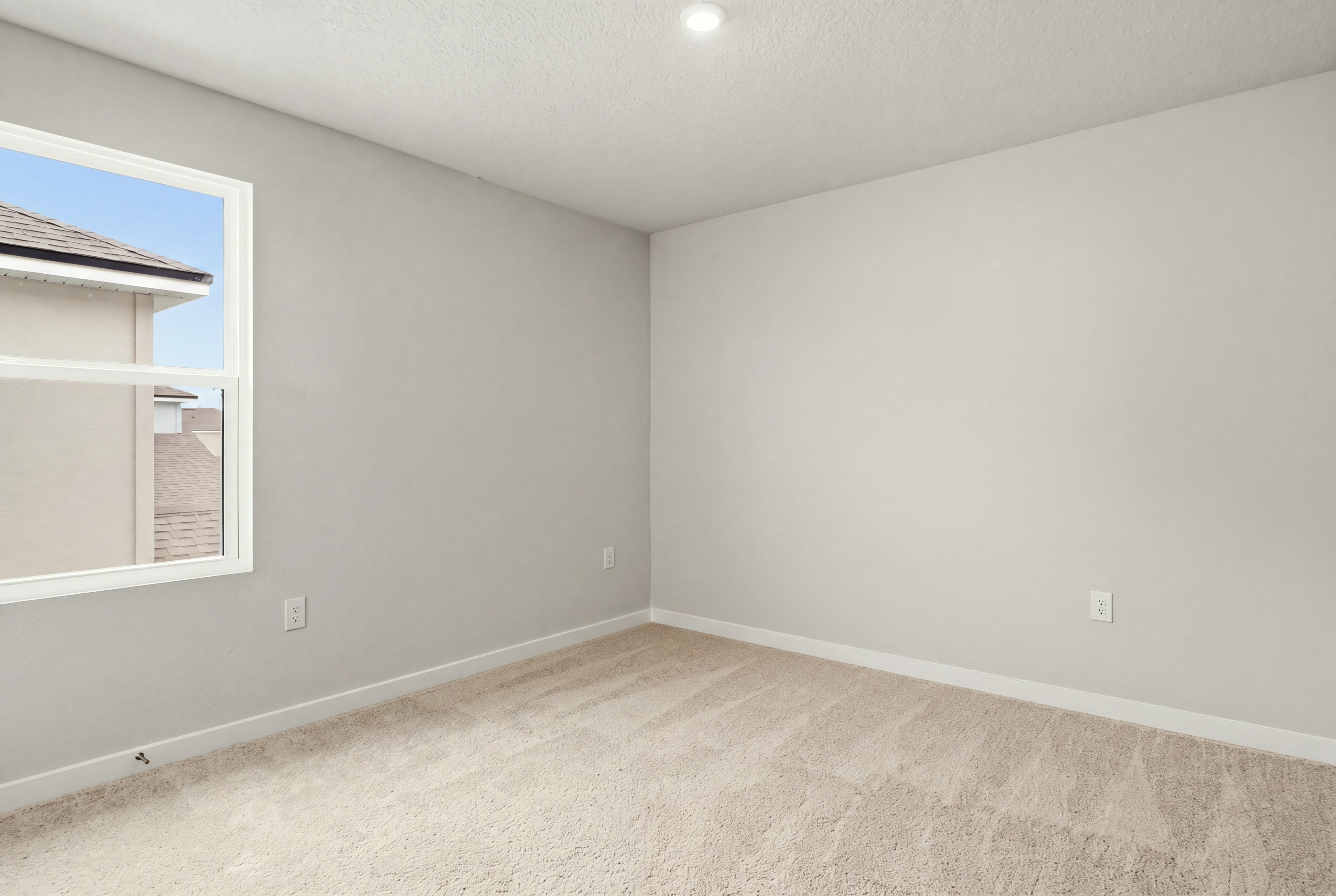 A room with a window and a carpet.