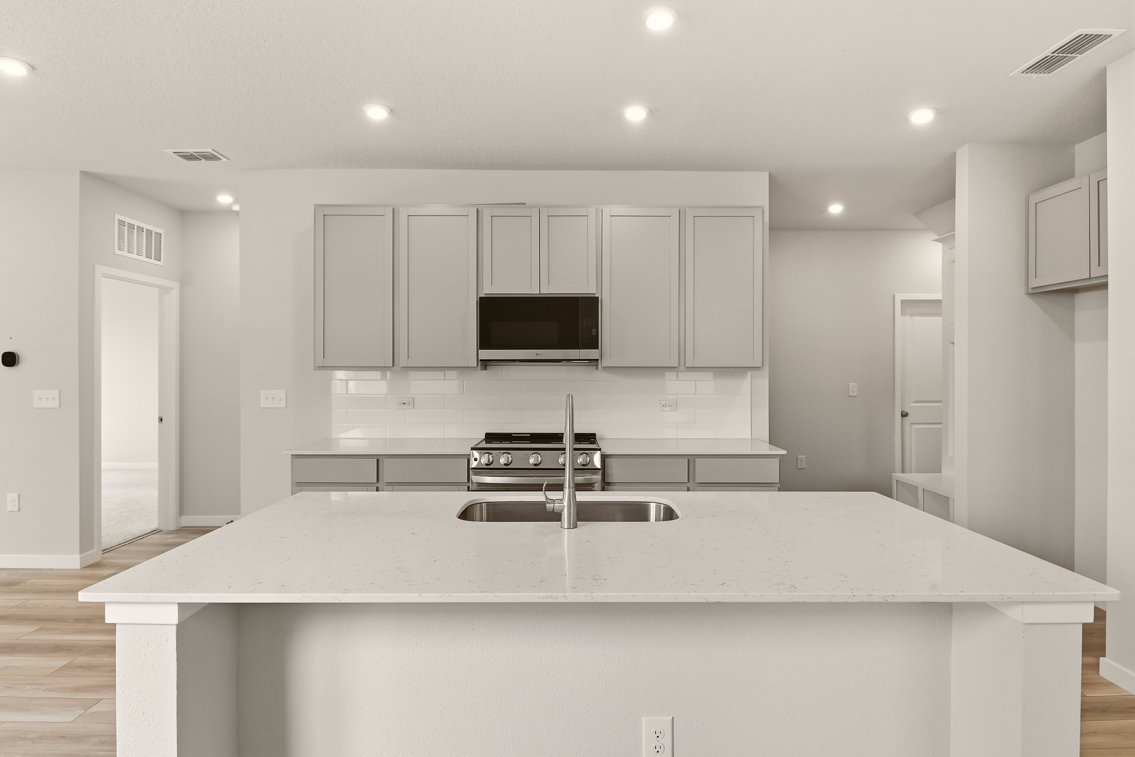 A kitchen with white cabinets.
