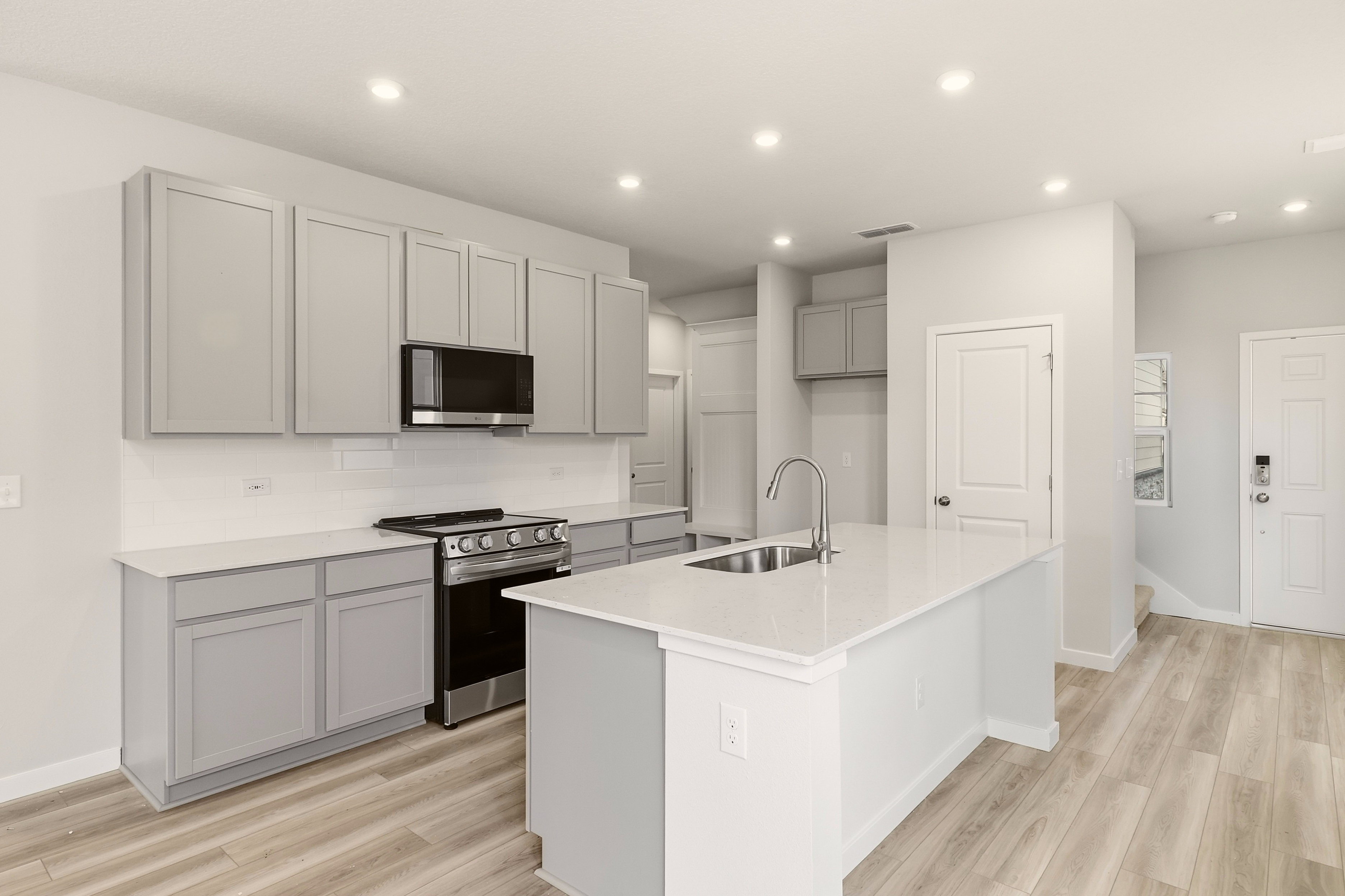 A kitchen with white cabinets.