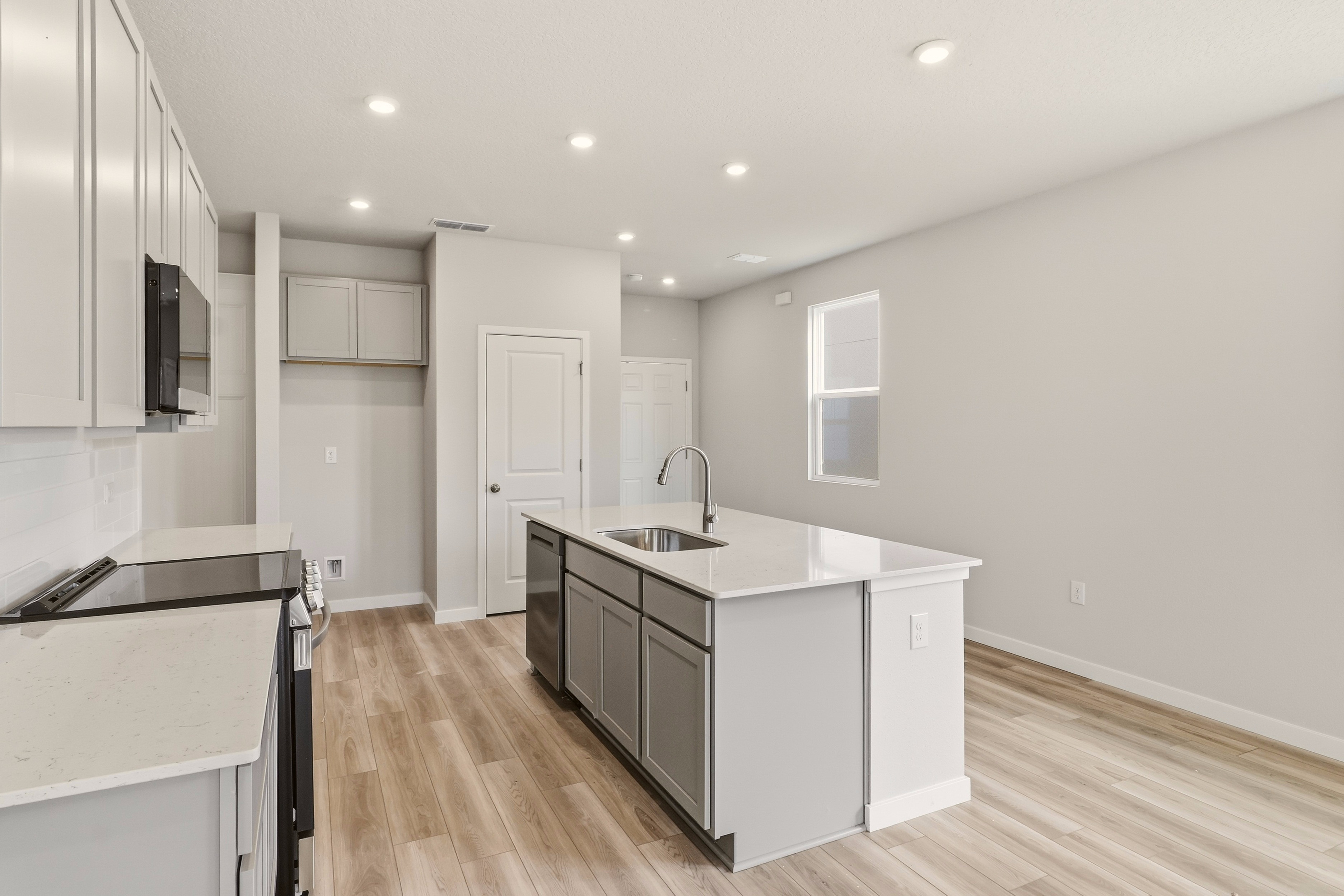 A kitchen with white cabinets.
