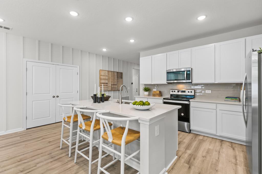 A kitchen with white cabinets.