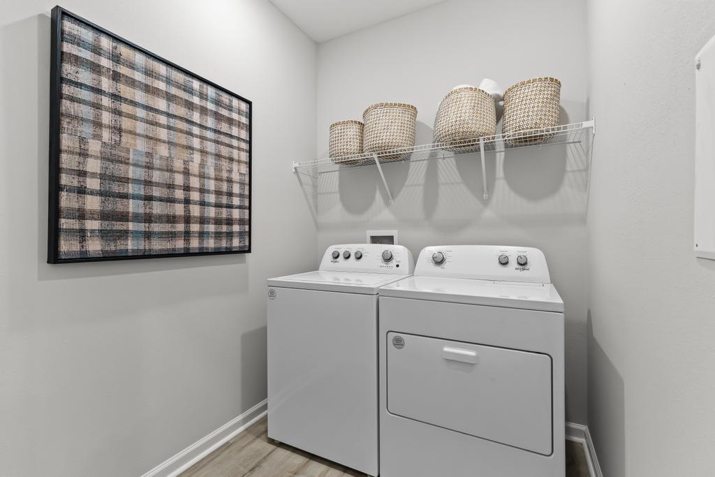 A white laundry room with a shelf with baskets on it.