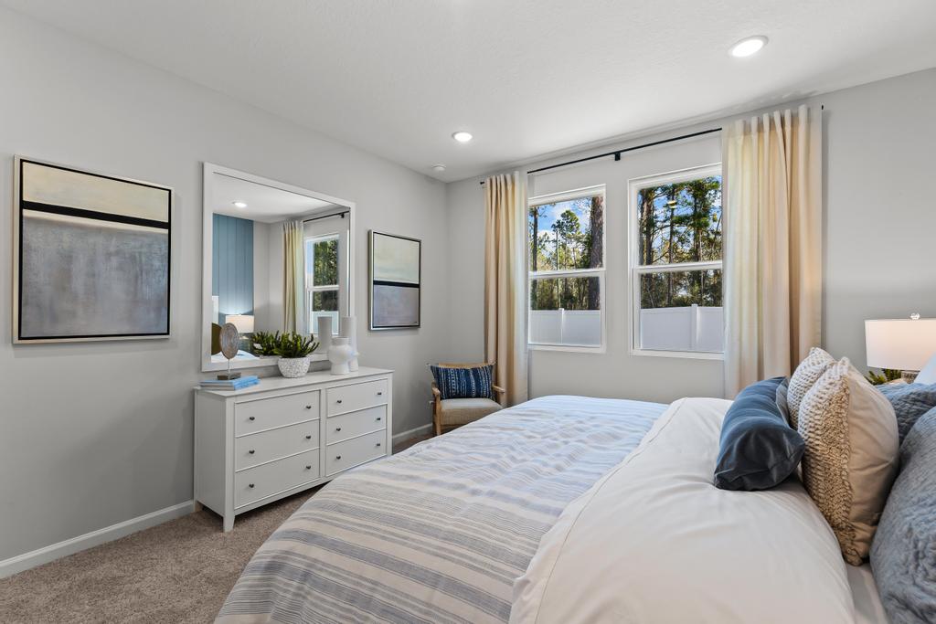 A bedroom with a bed and a mirror.