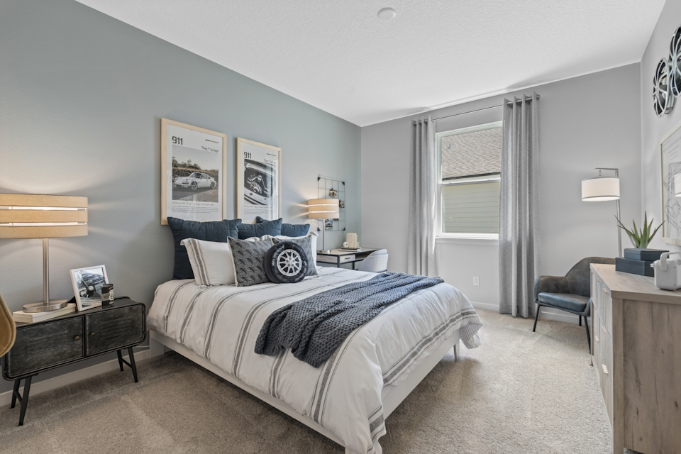 Coronado Model Home Guest Bedroom with Bed and Desk at Reserve East in Flagler Beach