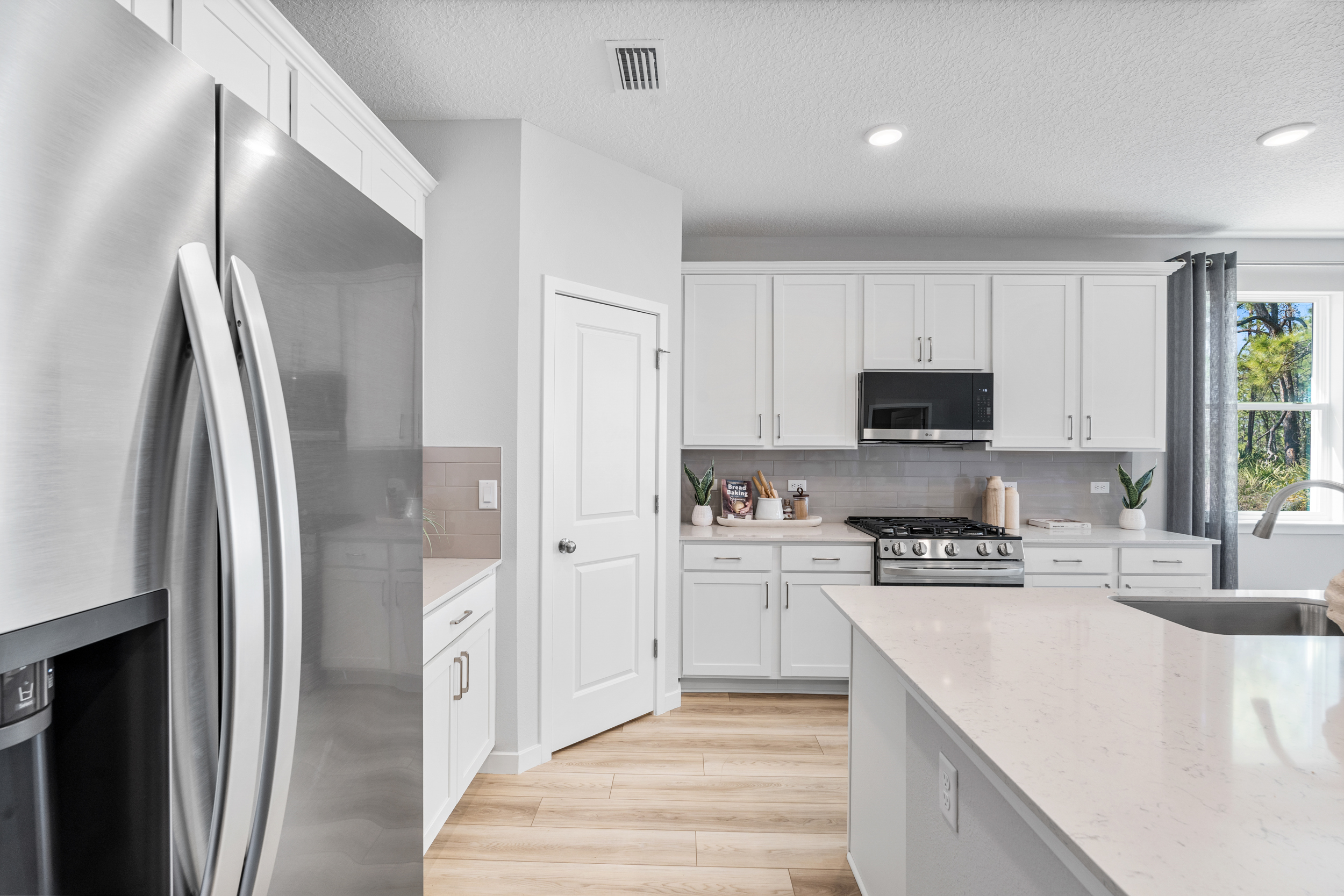 A kitchen with white cabinets.