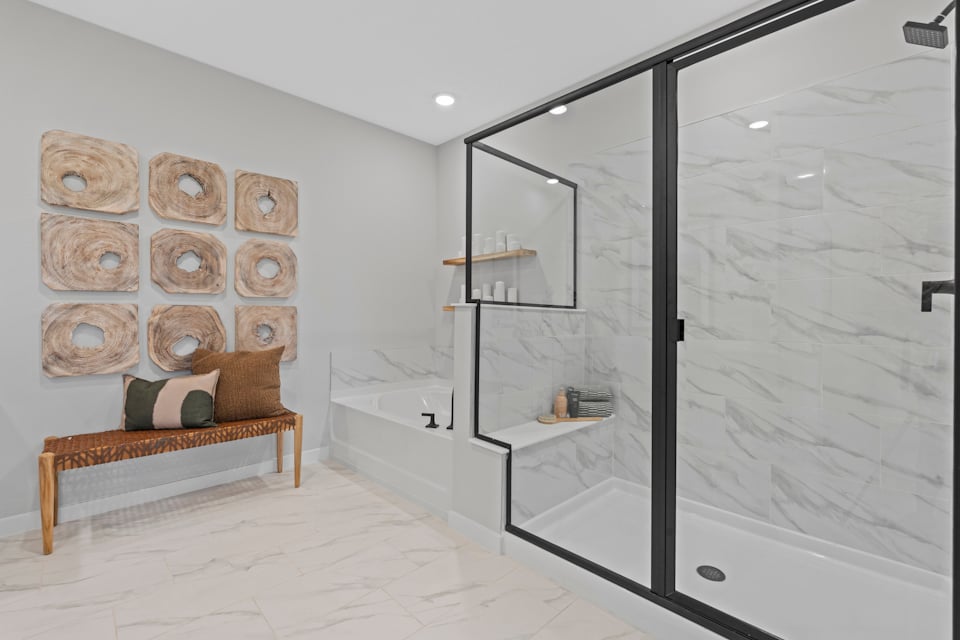 Kenai Model Home Primary Bathroom with Freestanding Tub and Glass Shower at Reserve East in Flagler Beach