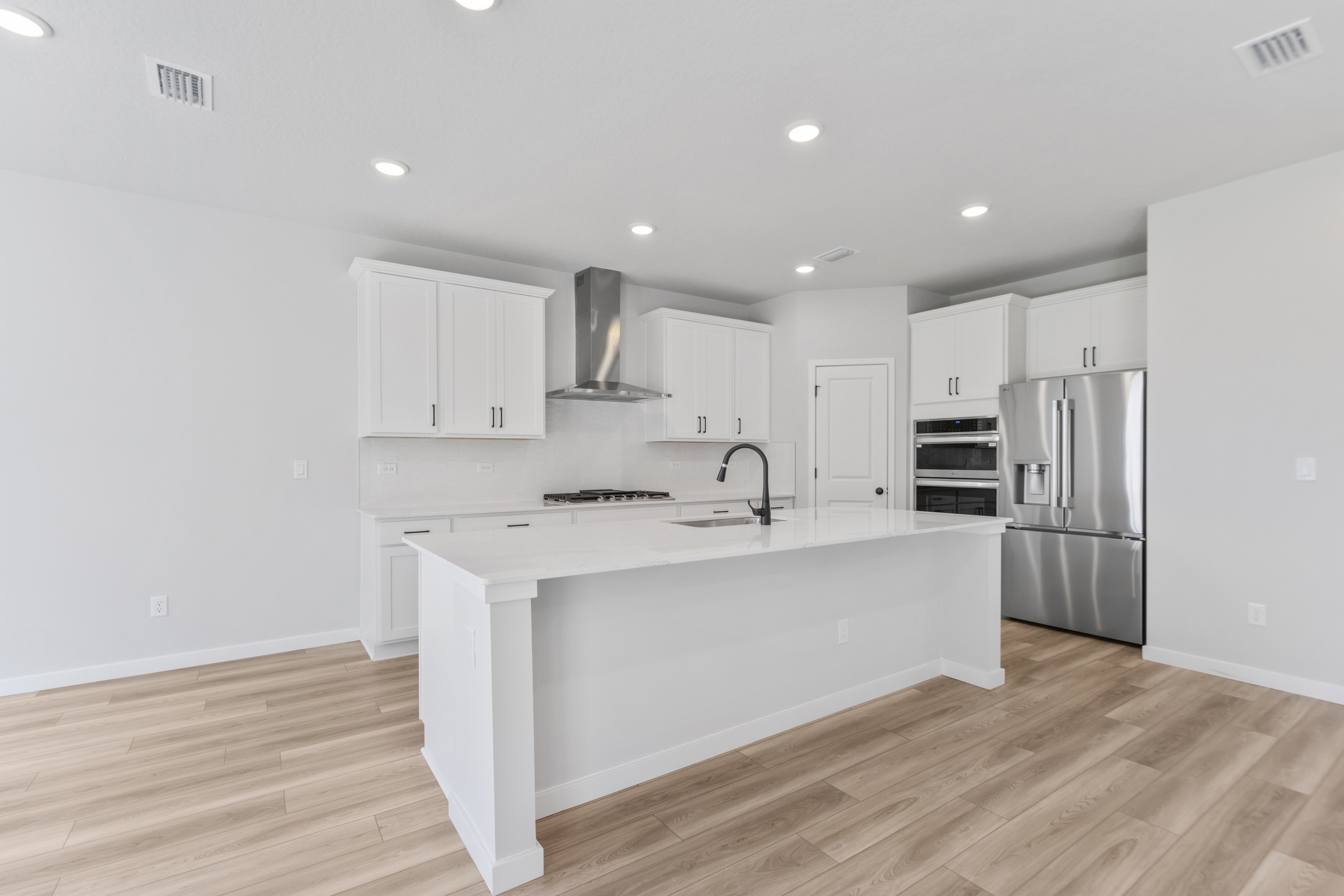 A kitchen with white cabinets.