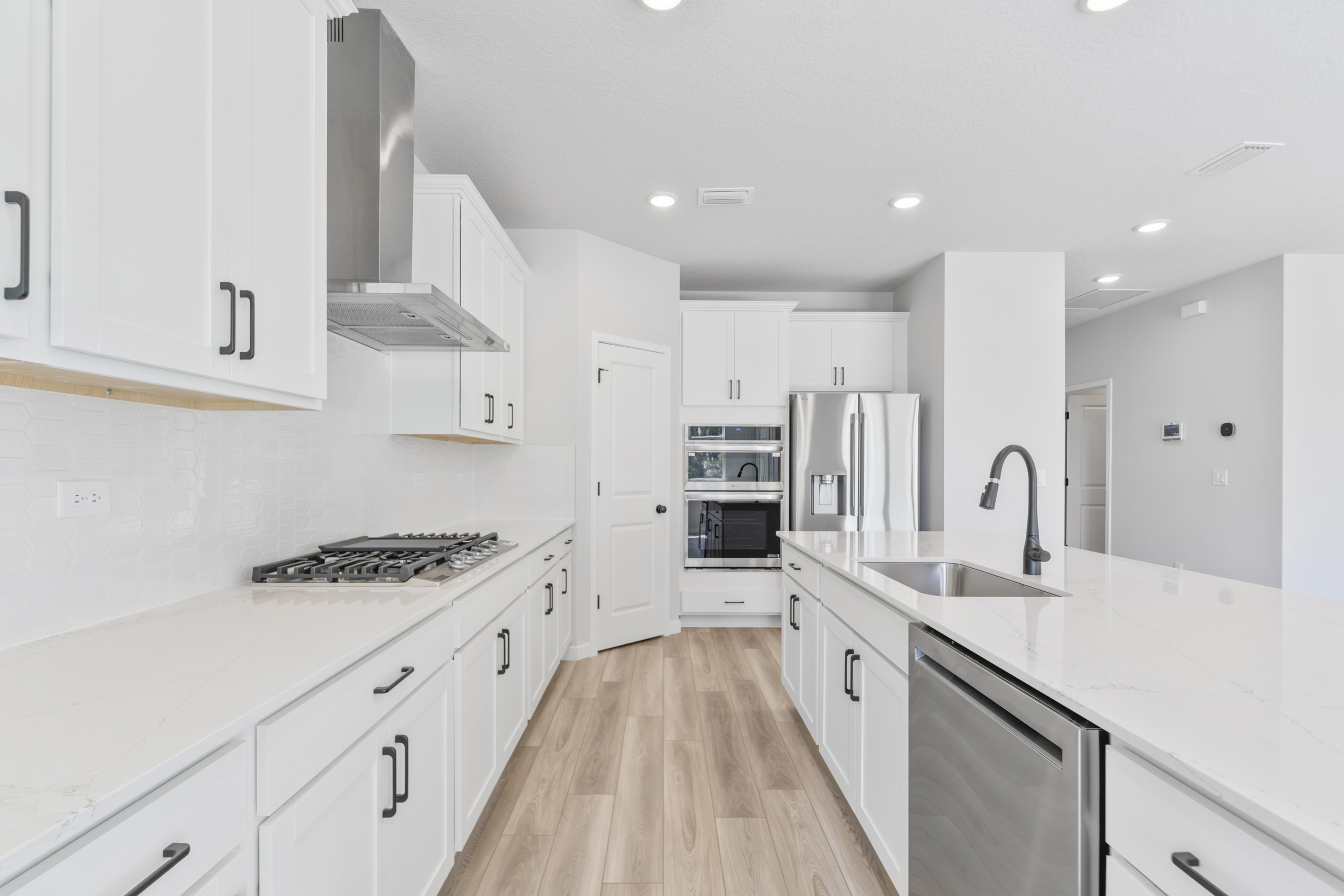 A kitchen with white cabinets.