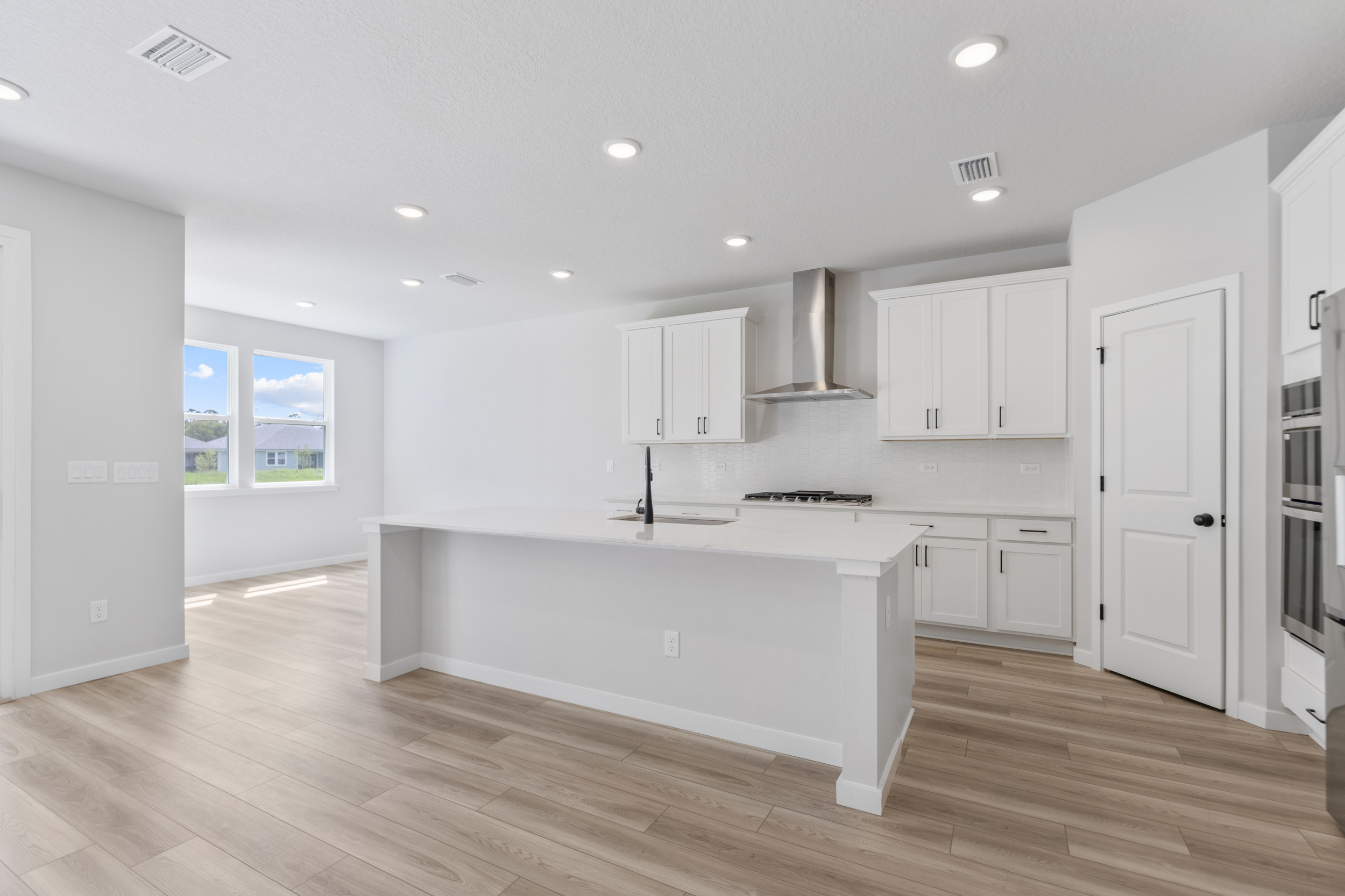 A kitchen with white cabinets.
