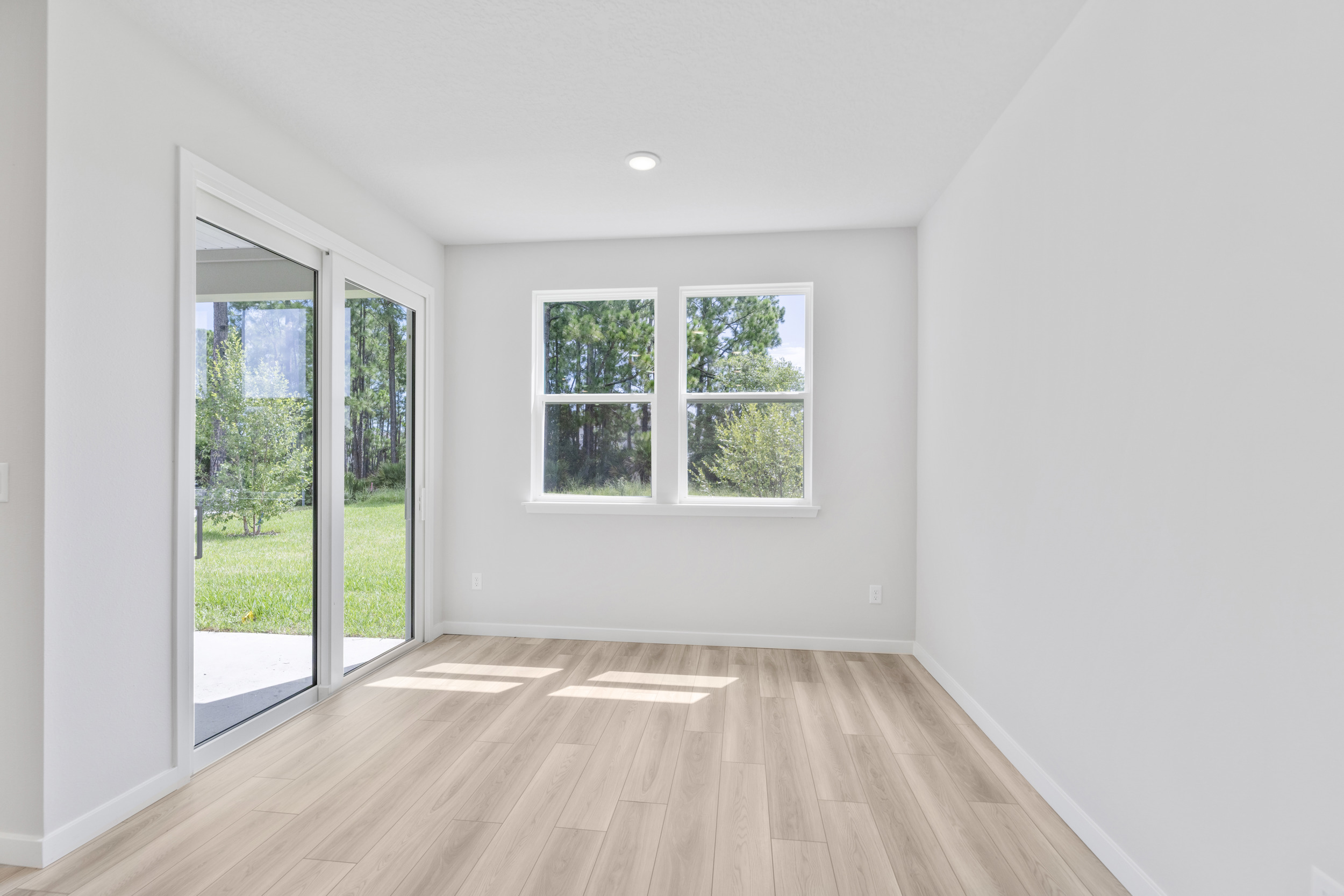 A room with a wood floor and windows.