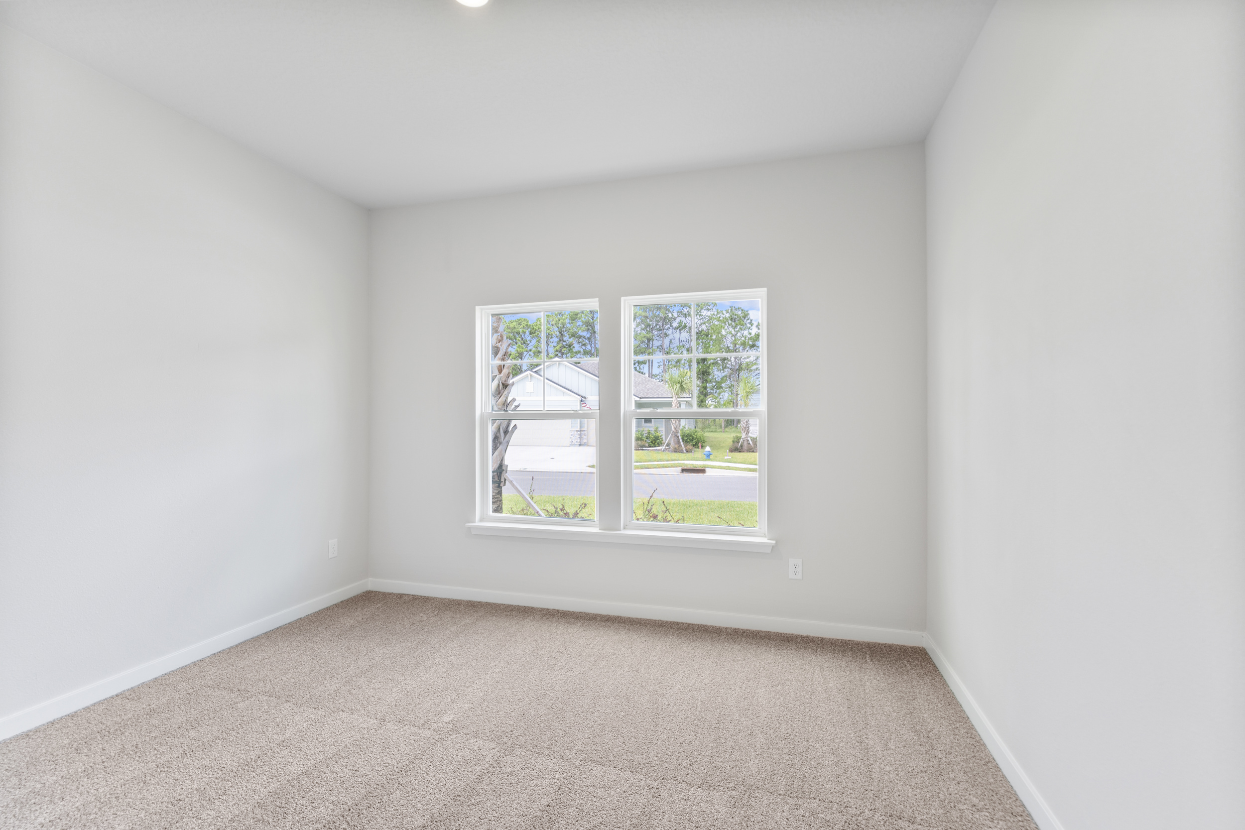 A room with a window and carpet.