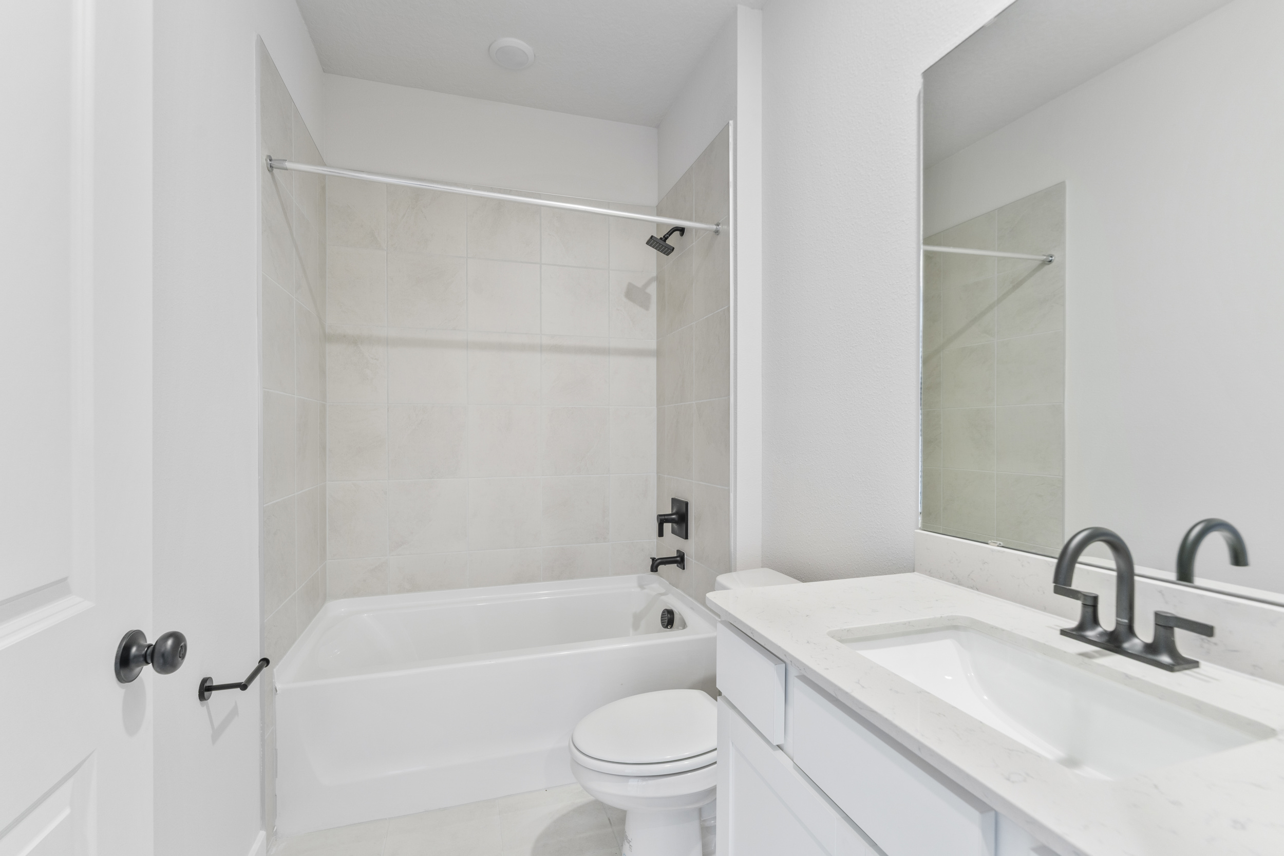A bathroom with a tub sink and toilet.