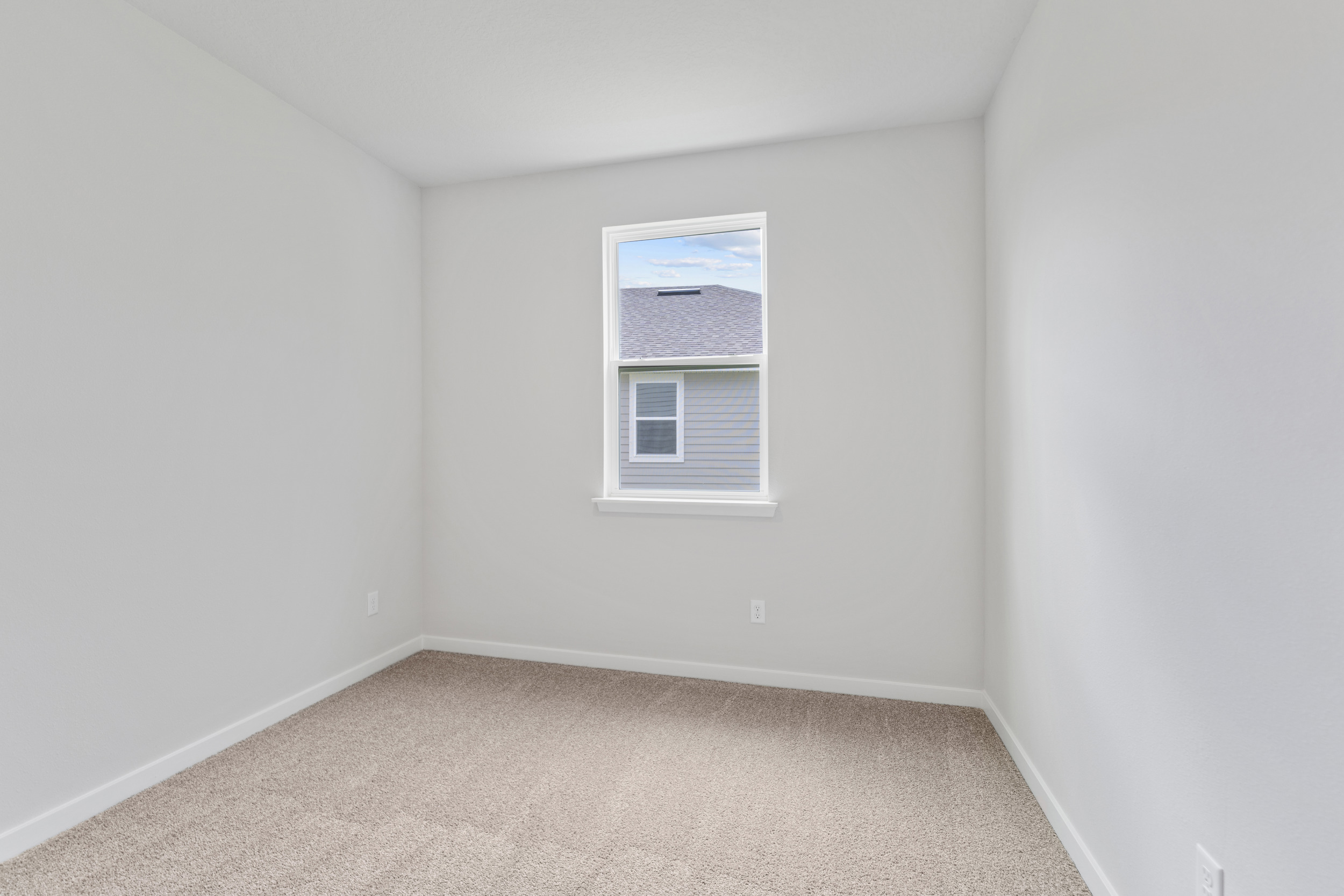 A room with a window and carpet.