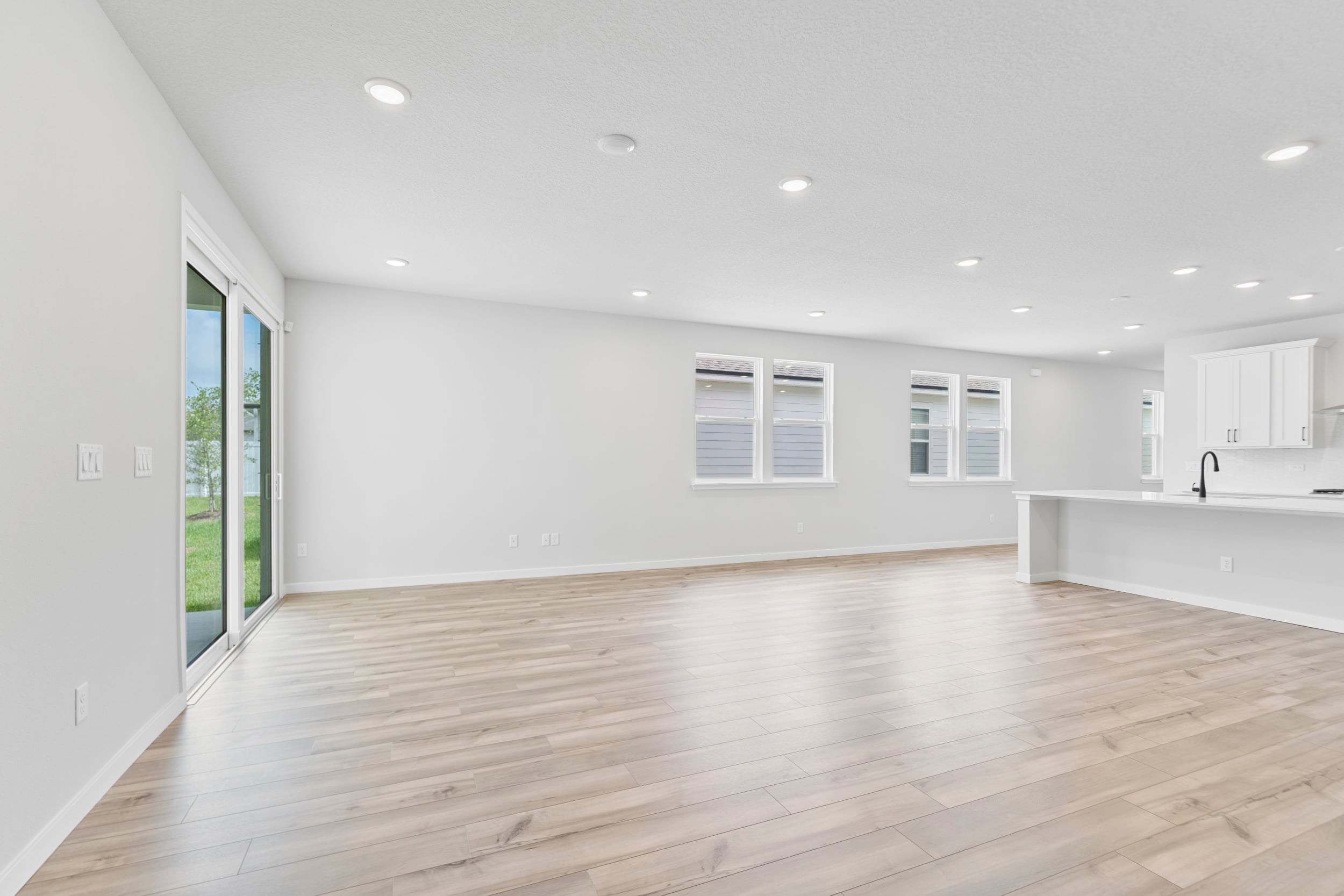 A large empty room with a wood floor and white walls.