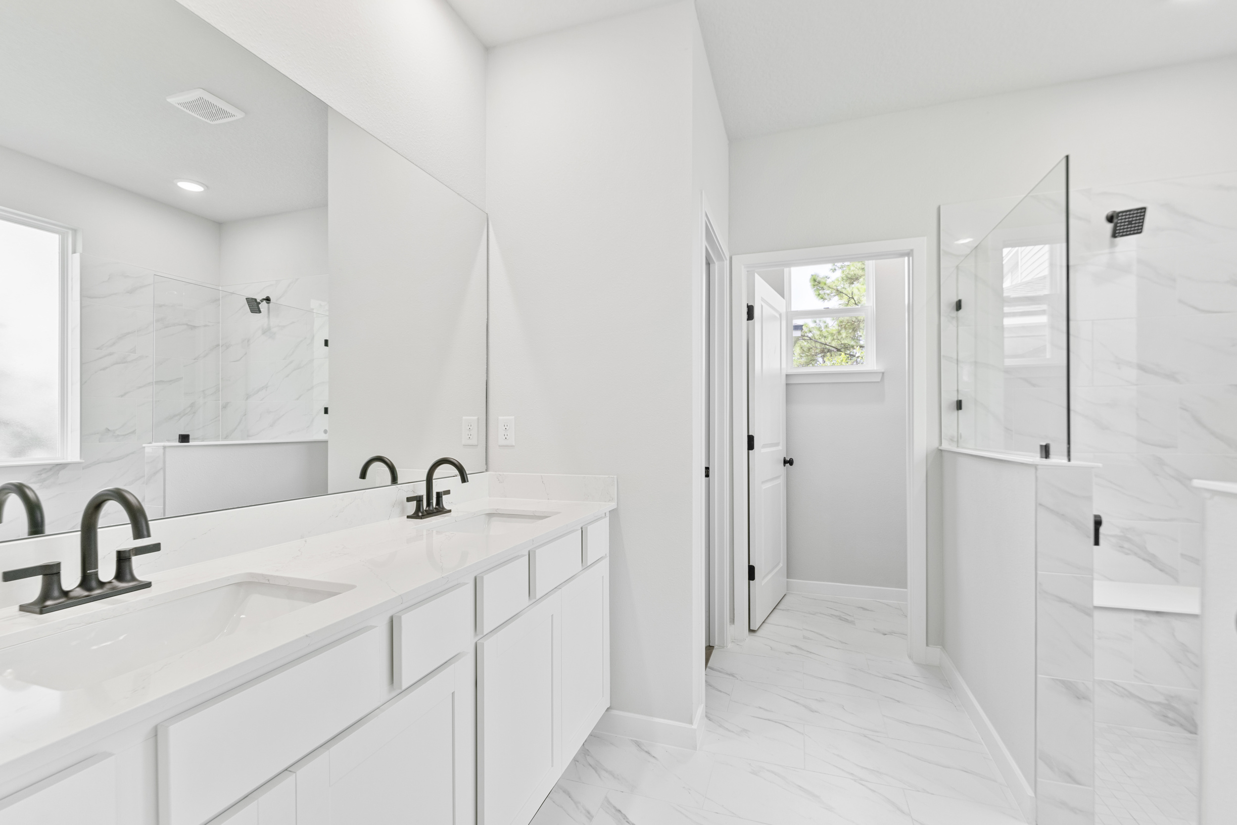 A bathroom with white cabinets.