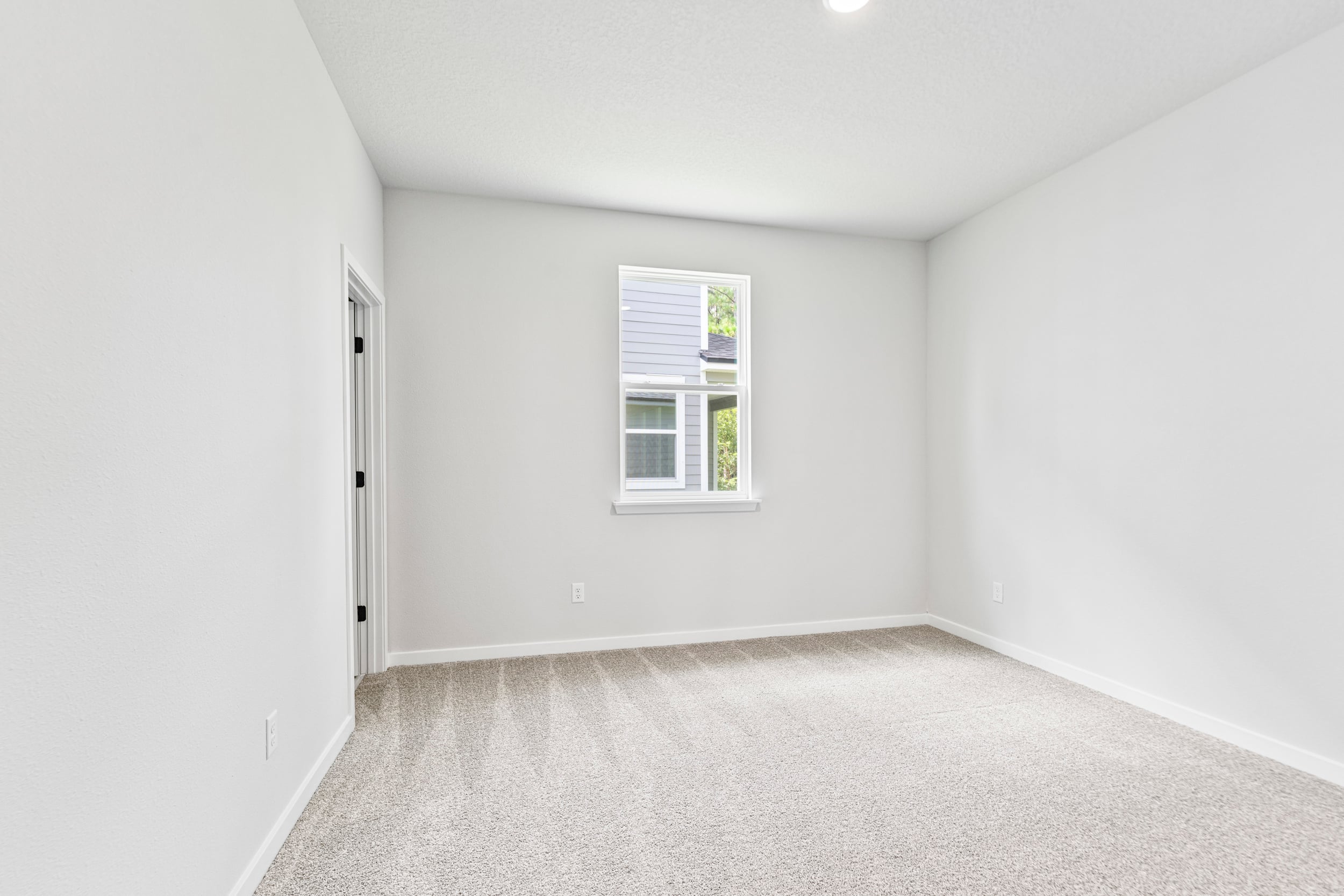 A room with a window and a carpet.