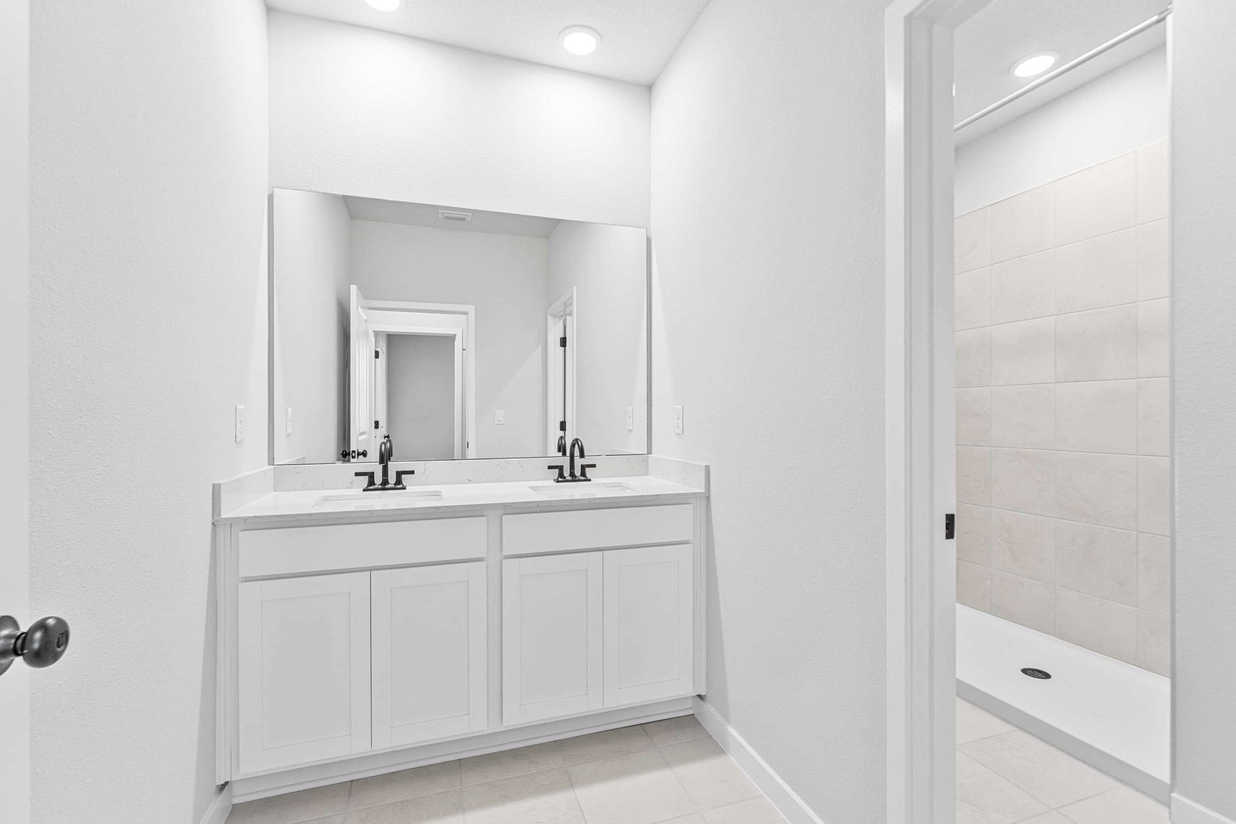 A bathroom with white cabinets.