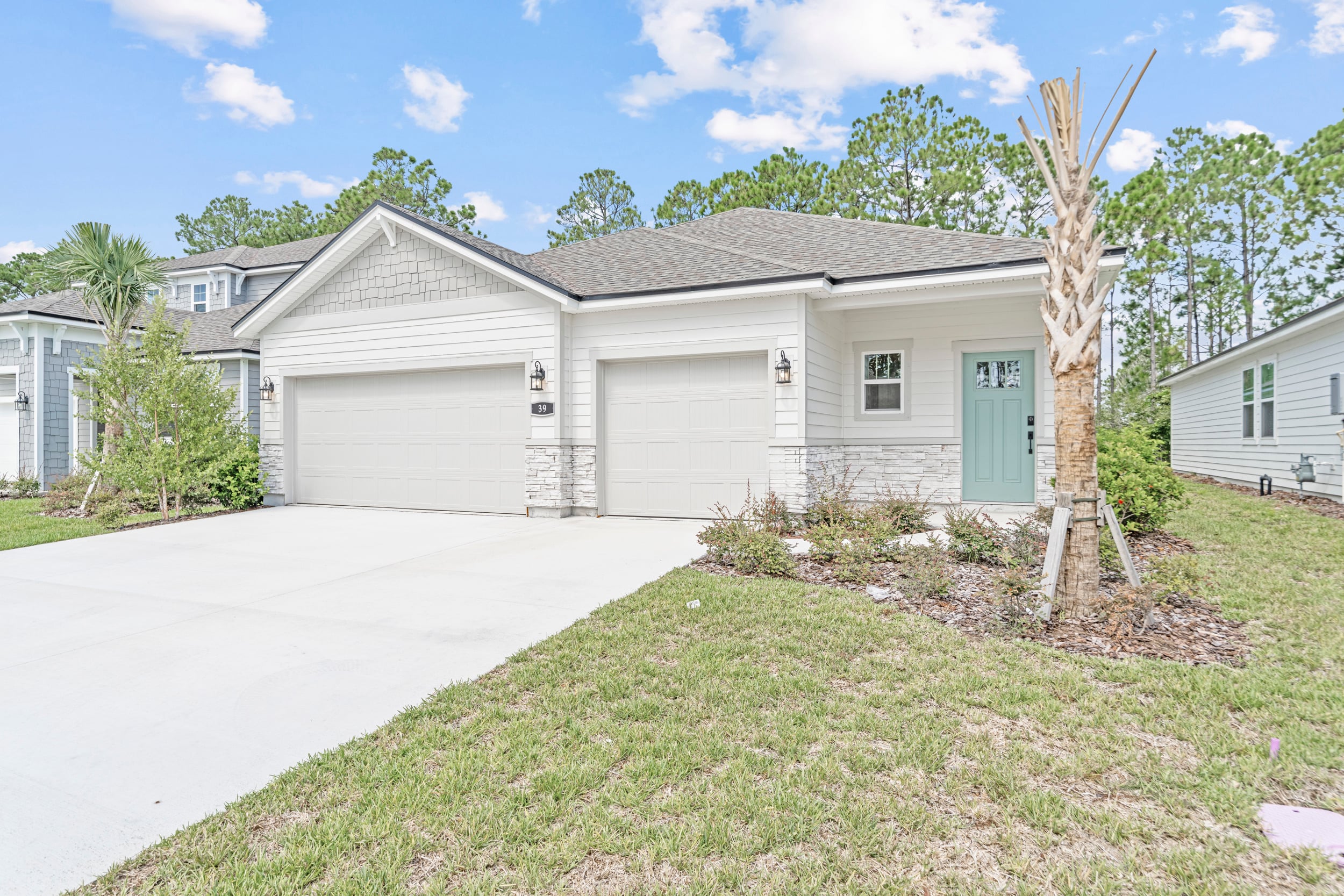 A house with garages and grass.