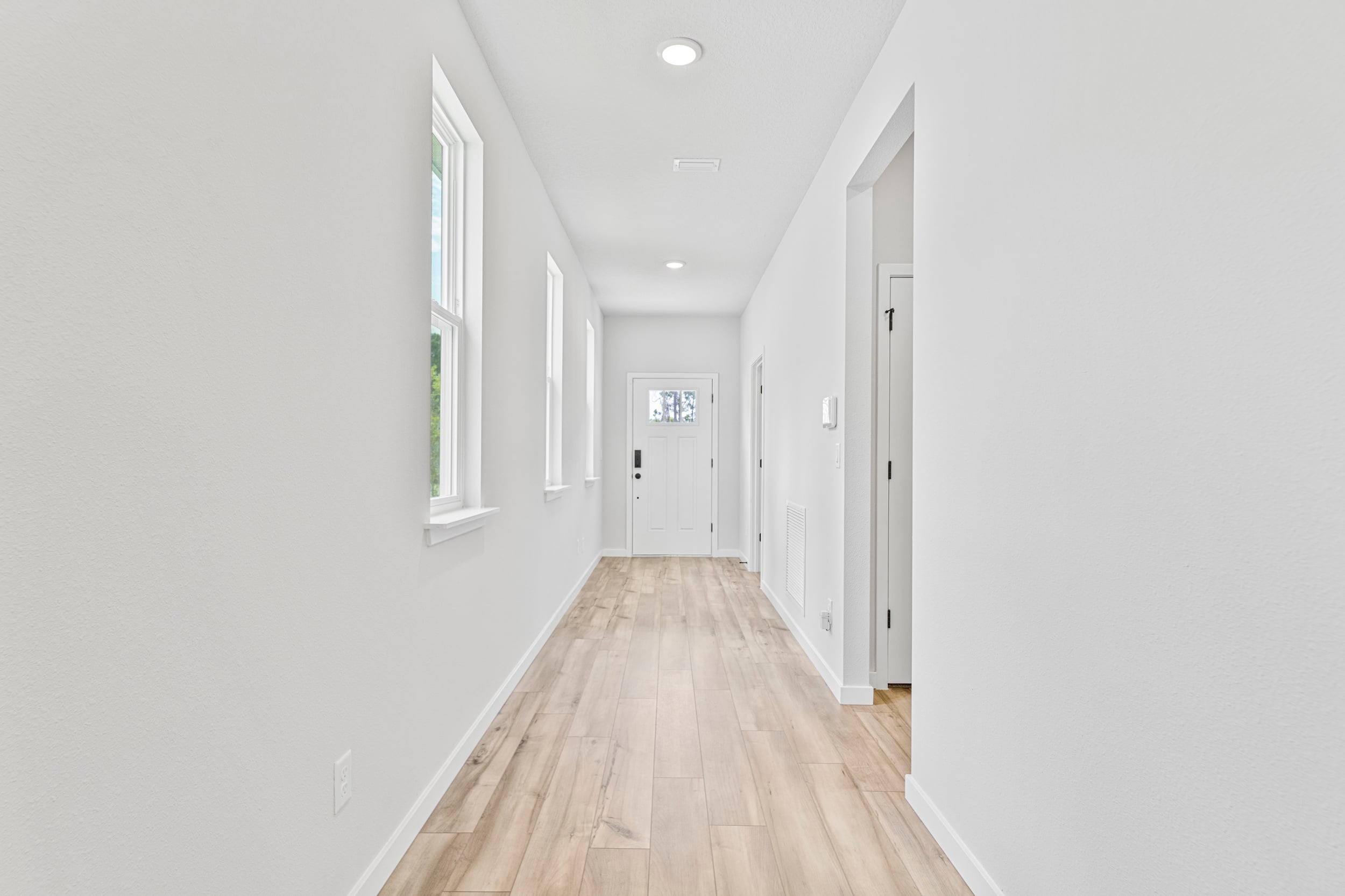 A long hallway with white doors.