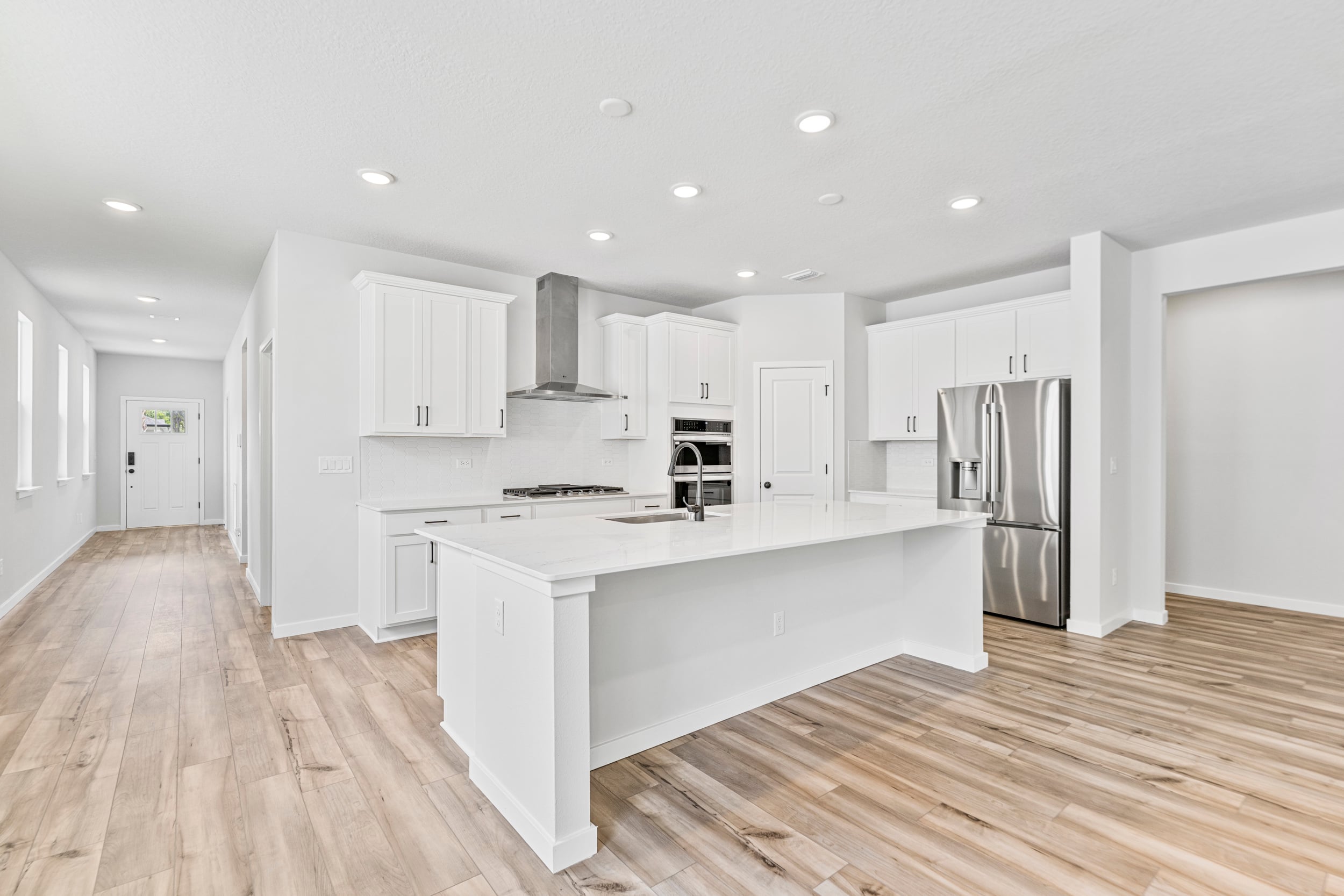 A kitchen with white cabinets.