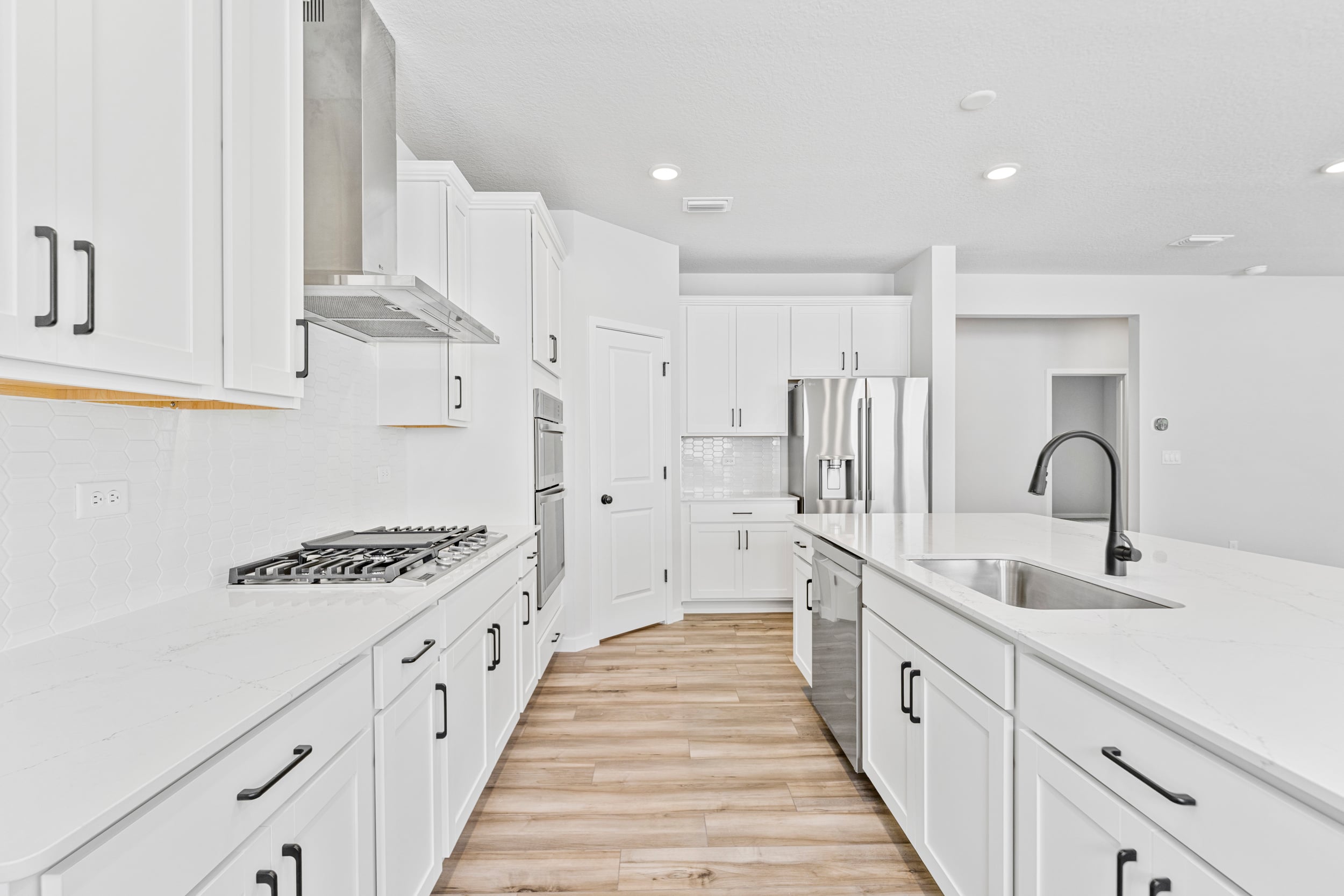 A kitchen with white cabinets.